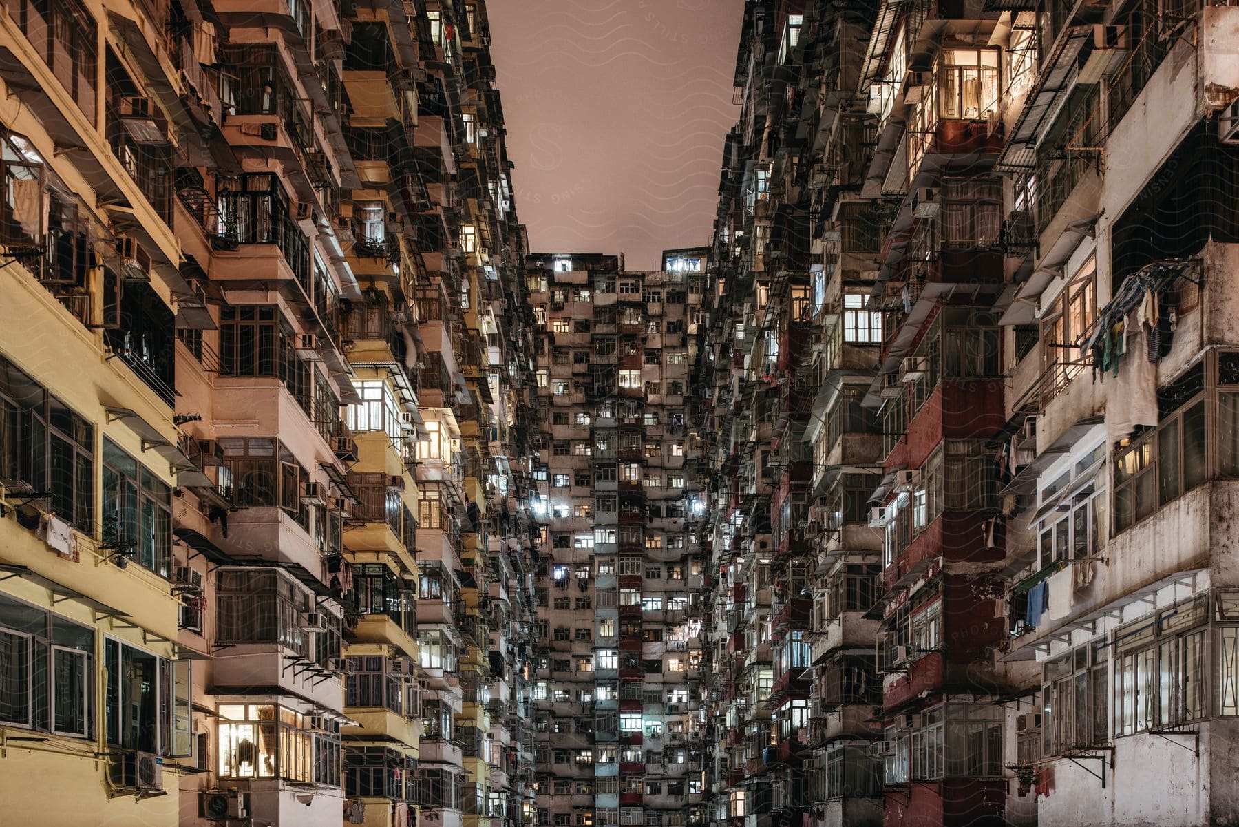 Tall residential buildings with many windows are seen in a city