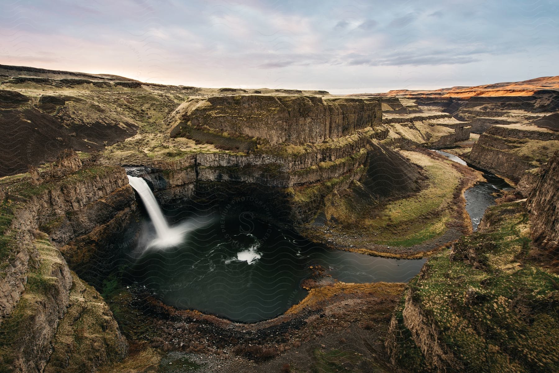 Stock photo of a waterfall cascades into a river basin