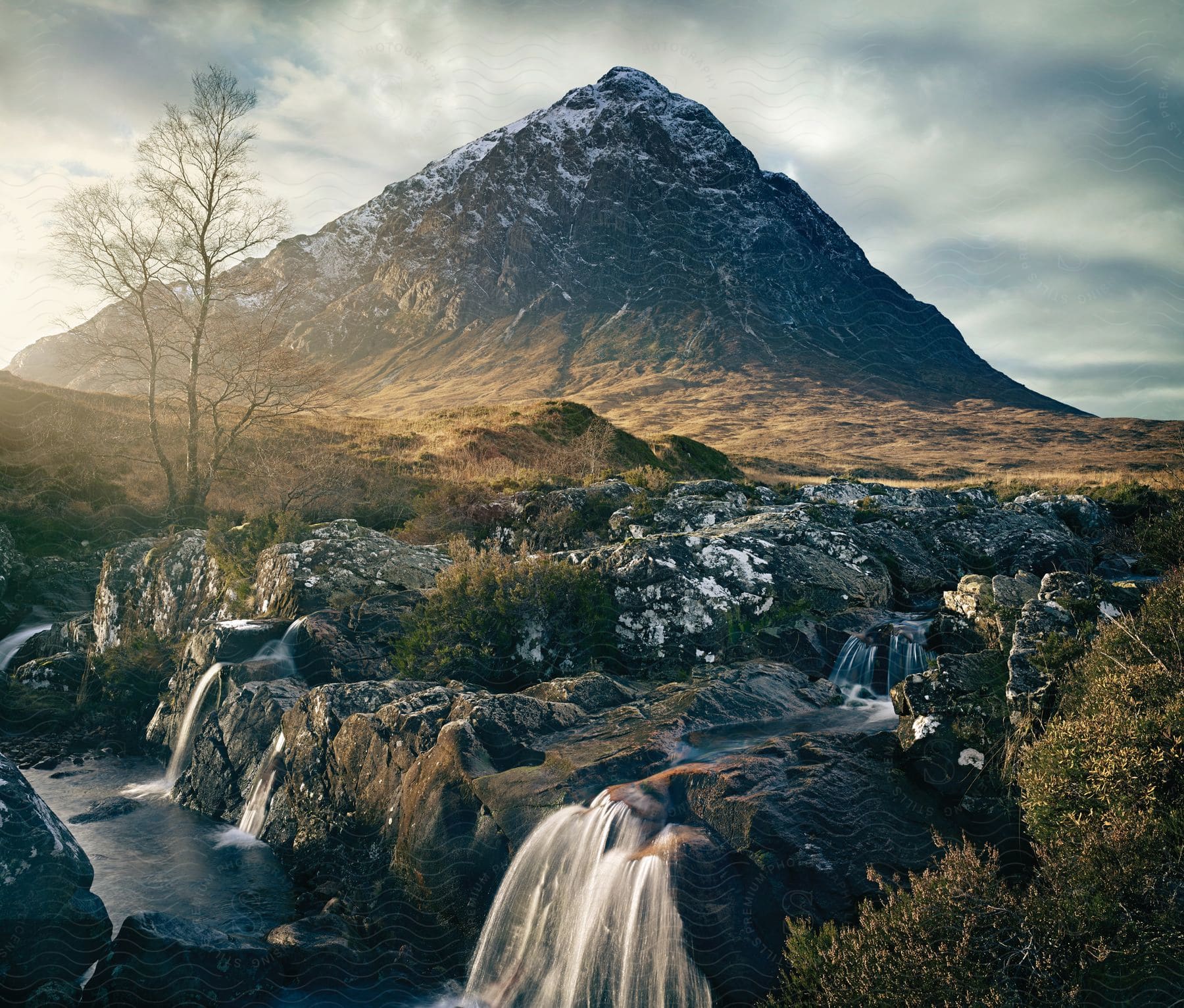 A rocky creek with a tall mountain peak in the background