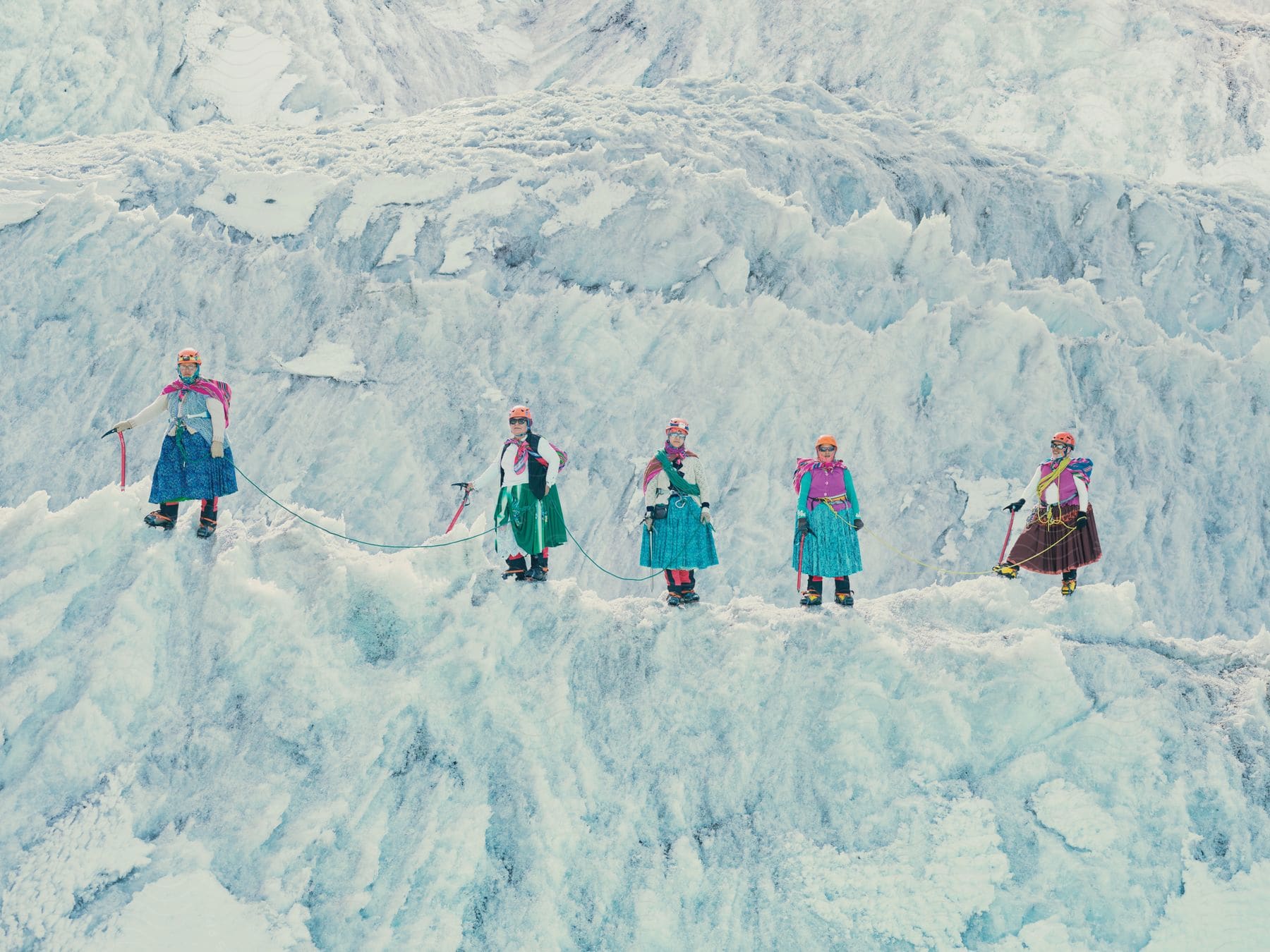 Five determined women scaling a treacherous icy mountain with climbing gear and sturdy boots