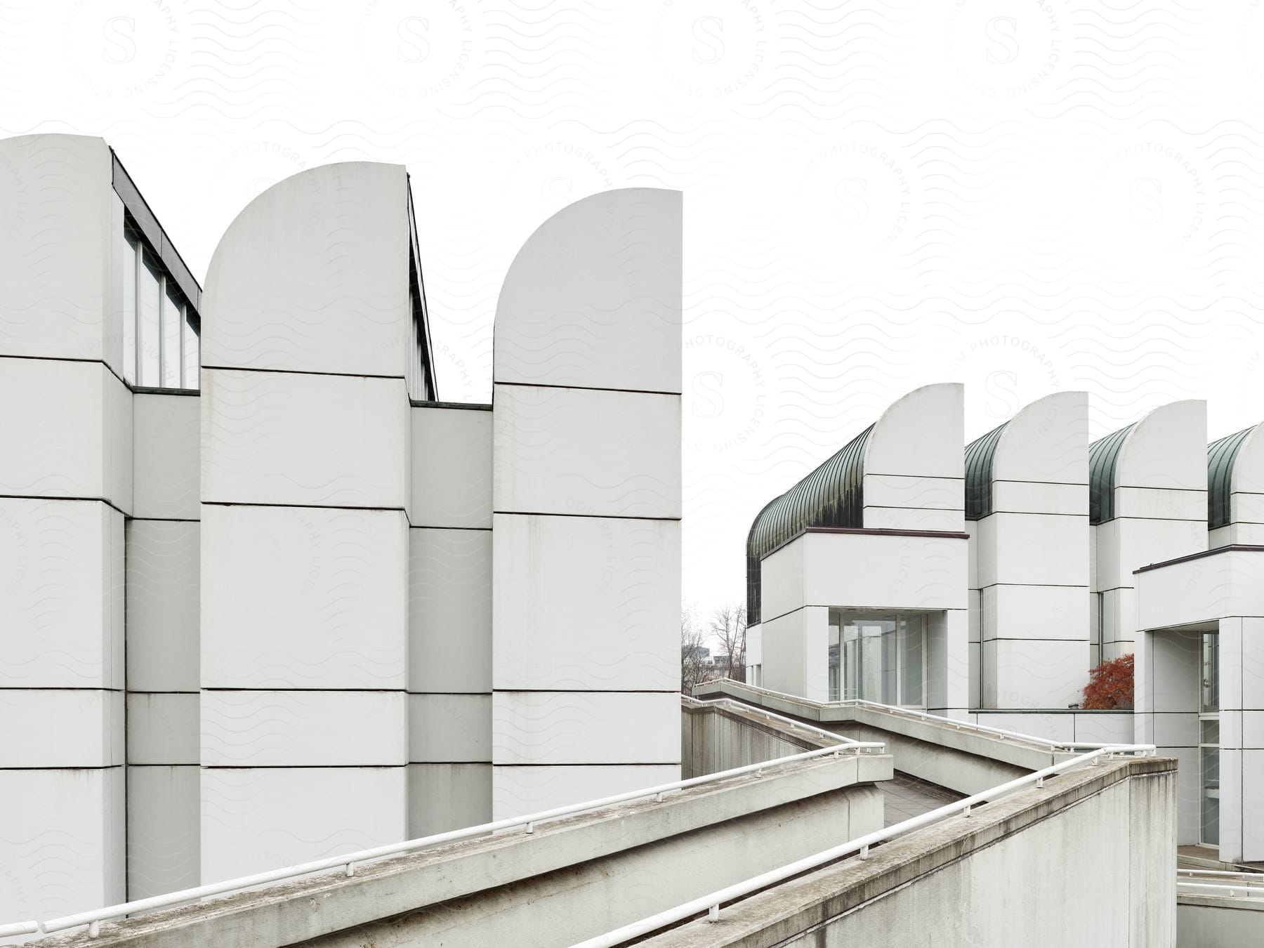 Exterior of a museum with a handrail and office building in the background