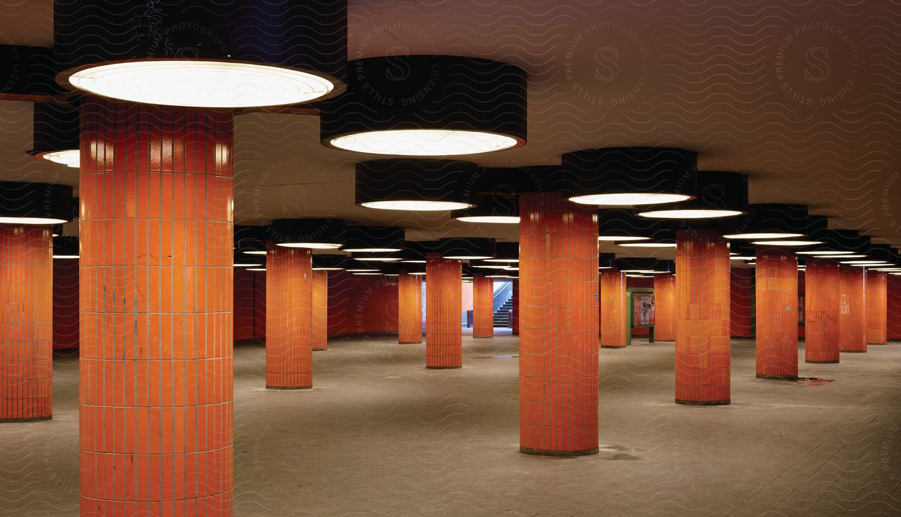 An empty underground parking lot with a series of red columns and round lights