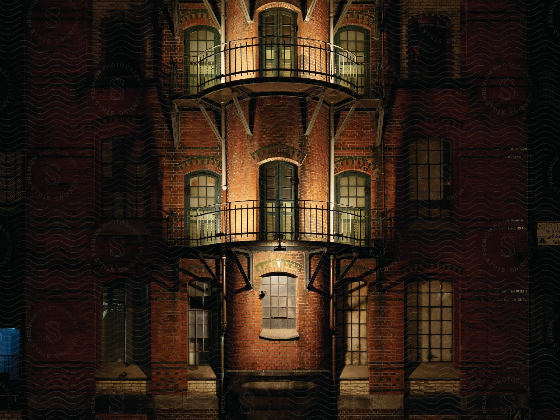 A building with multiple windows and balconies at night