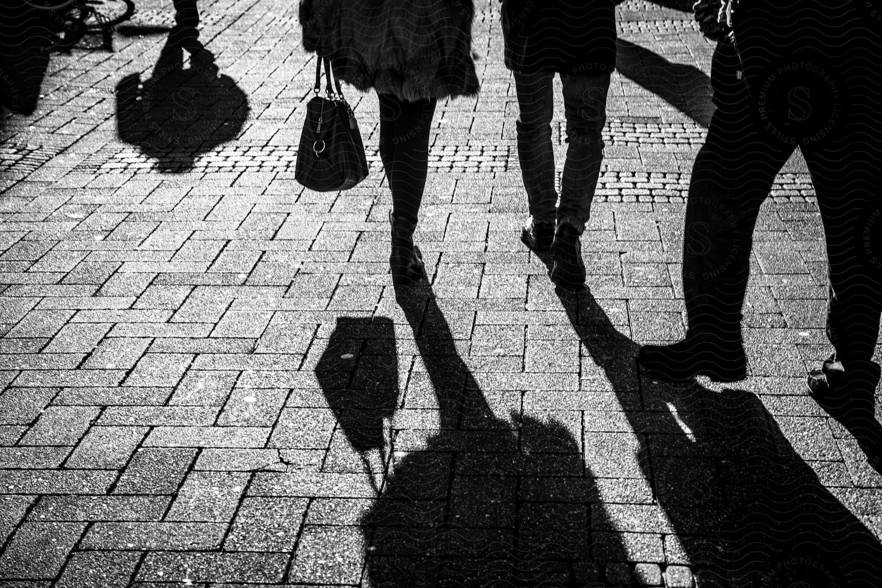 People Walking Down A Bricklined City Street