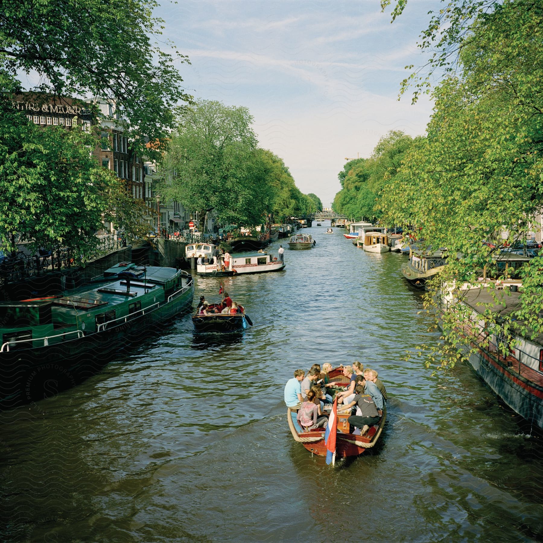 People in small boats on a canal in the middle of the city