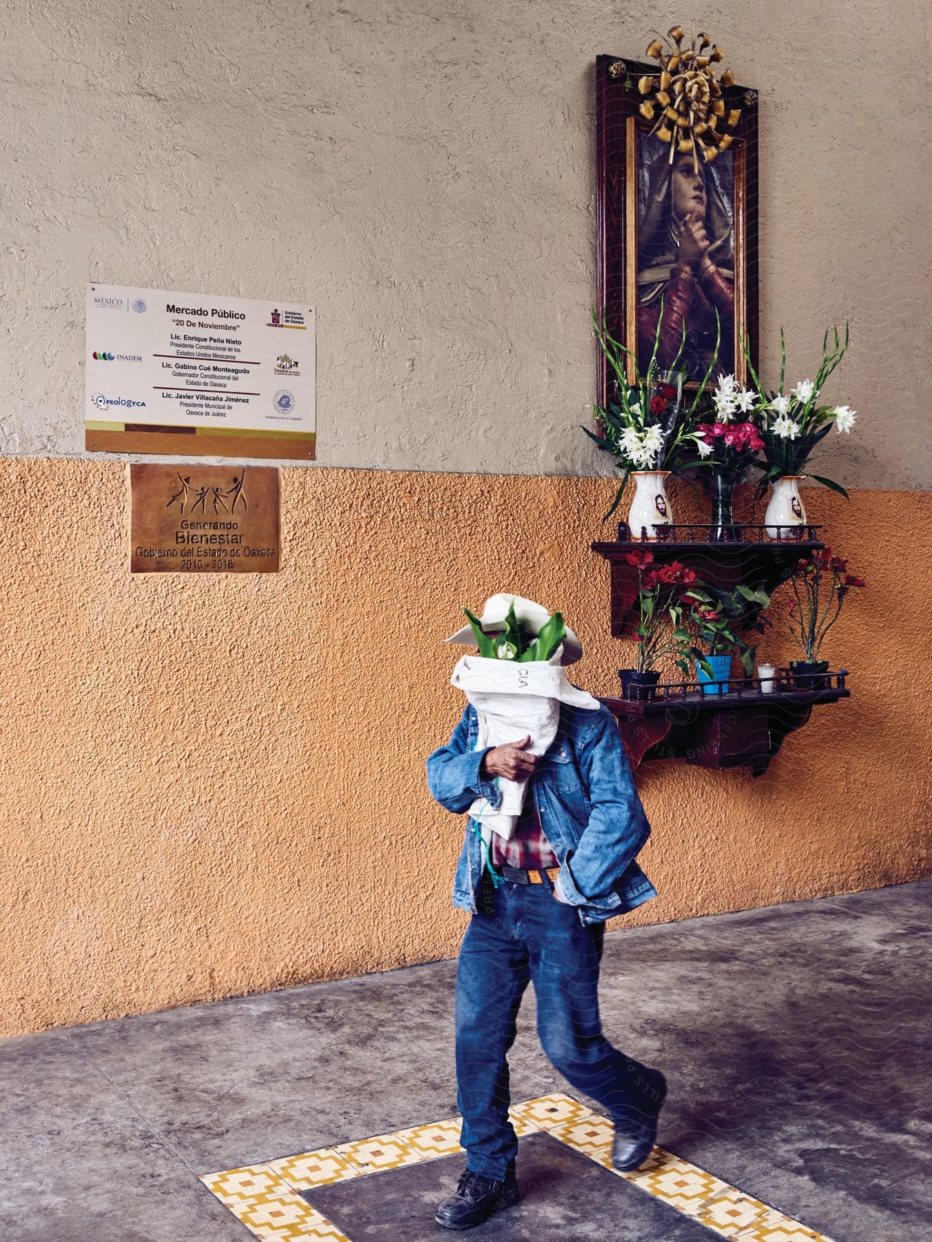 A man walking with flowers in front of his face