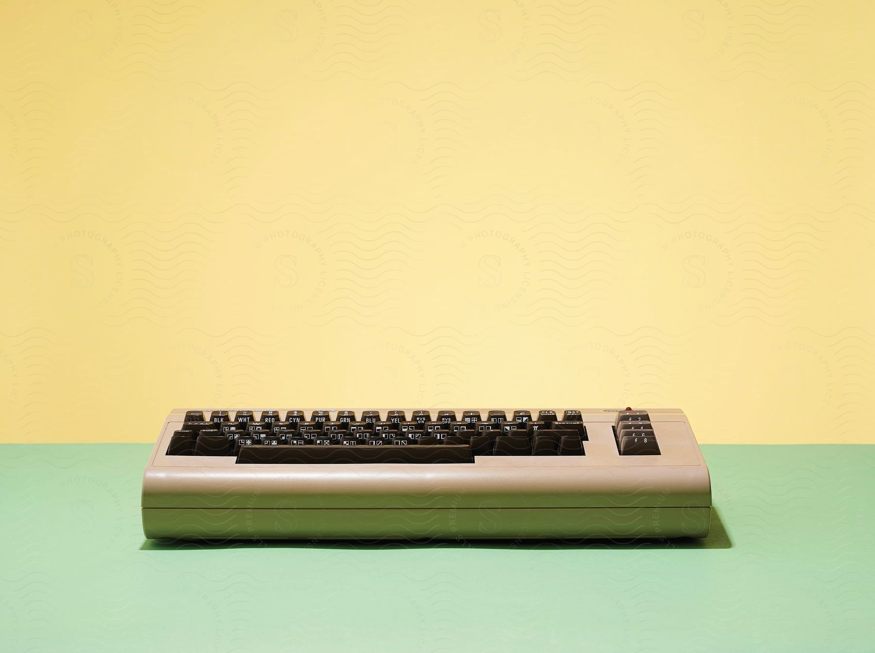 An antique keyboard on a pastel color background