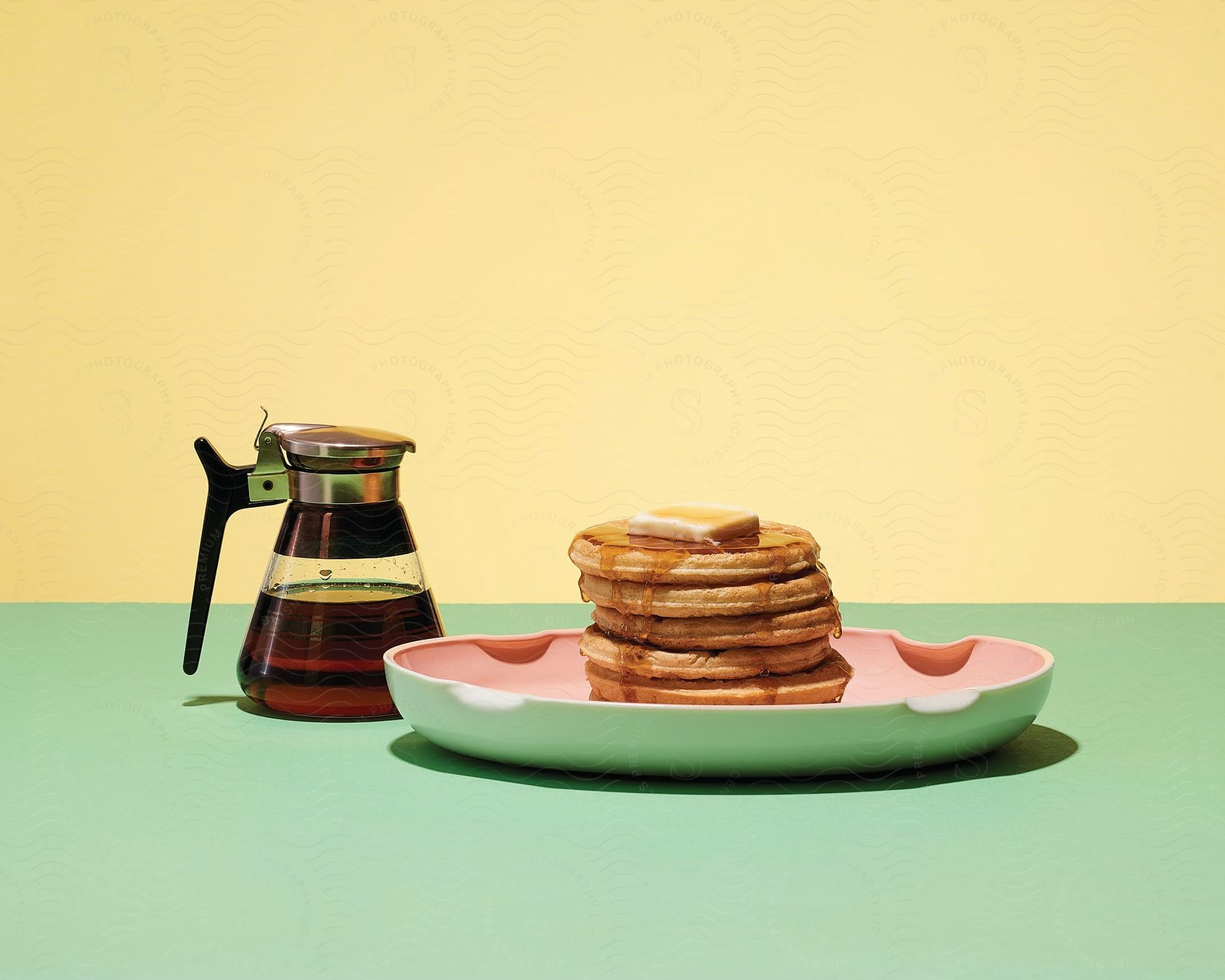 Green table with a coffee pot and a plate of pancakes