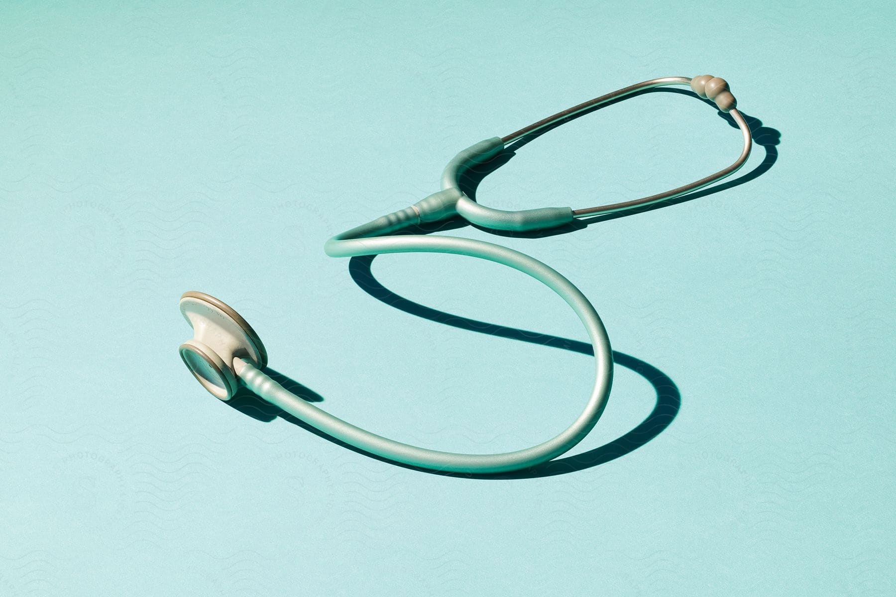 A stethoscope on a teal surface