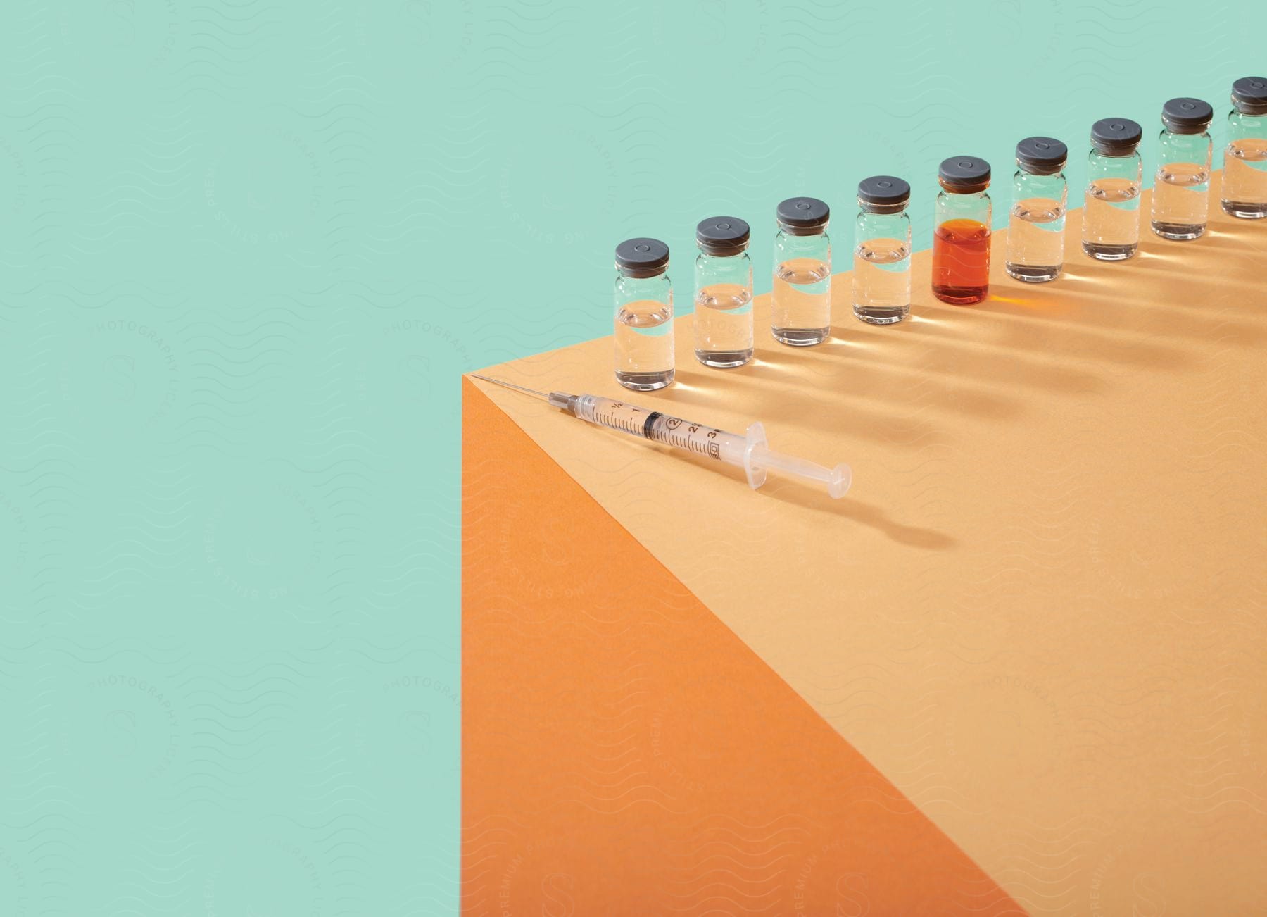 A syringe and medicine vials arranged in a line