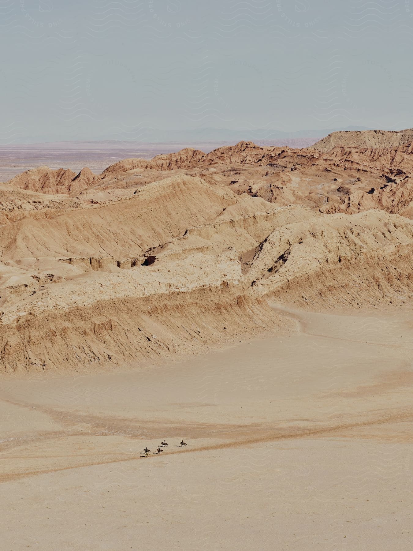 Canyons snake through mountain terrain in the middle of a hazy arid plain