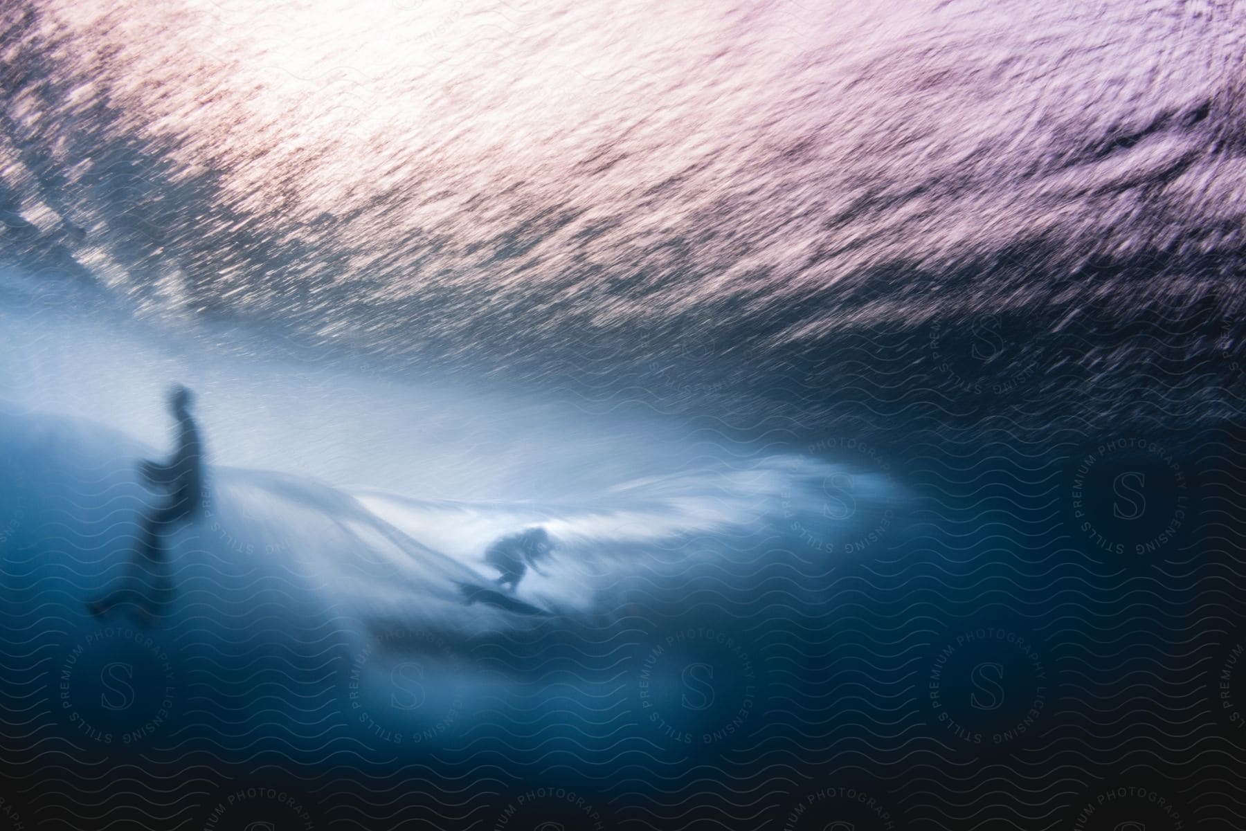 Two people are surfing on waves in the ocean