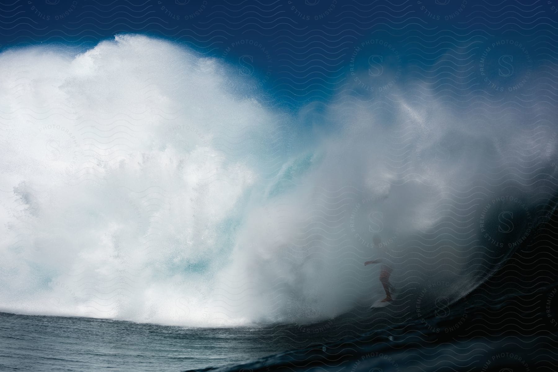 A person surfs on a wave in the open ocean