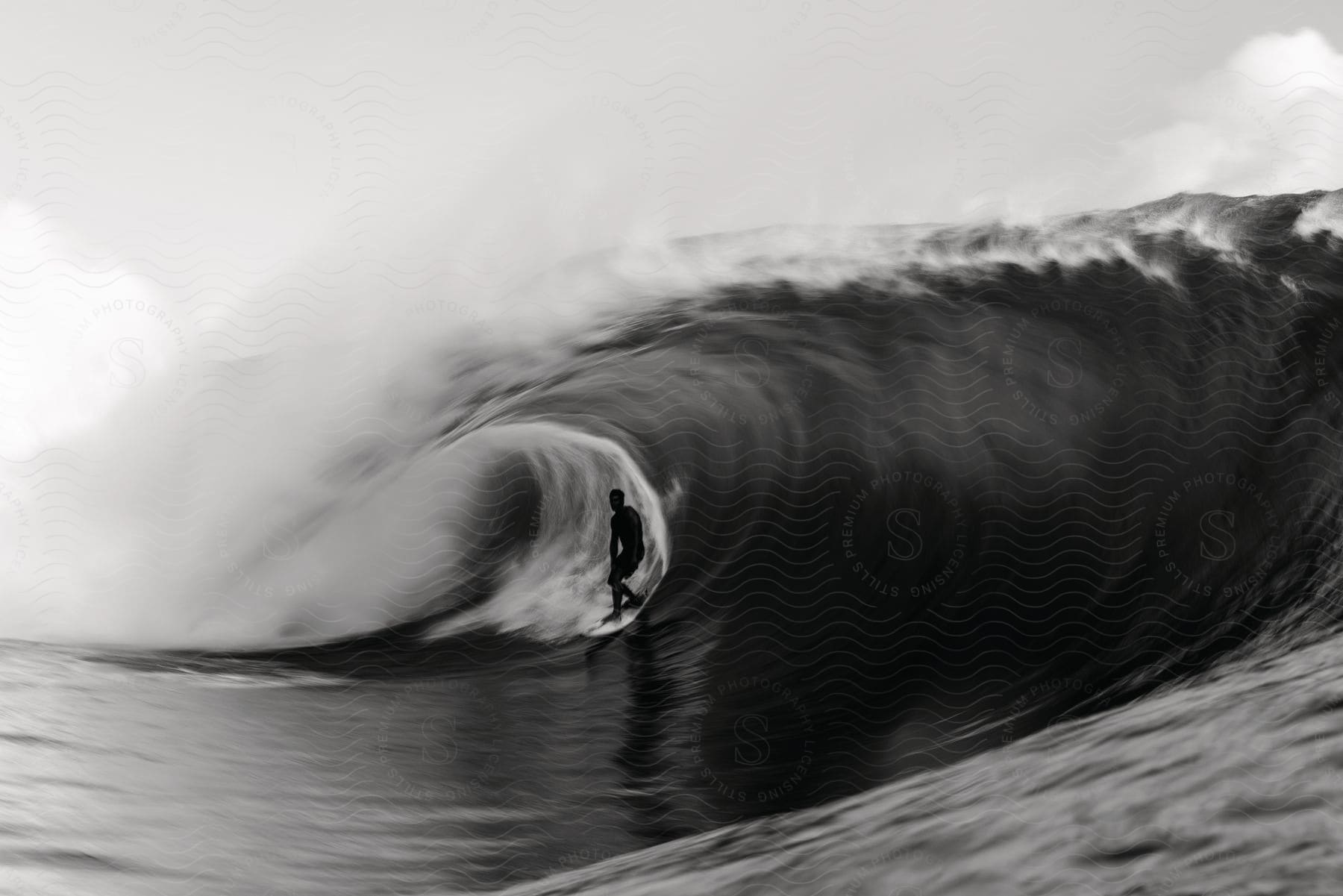 A person surfing in the ocean just under the wave