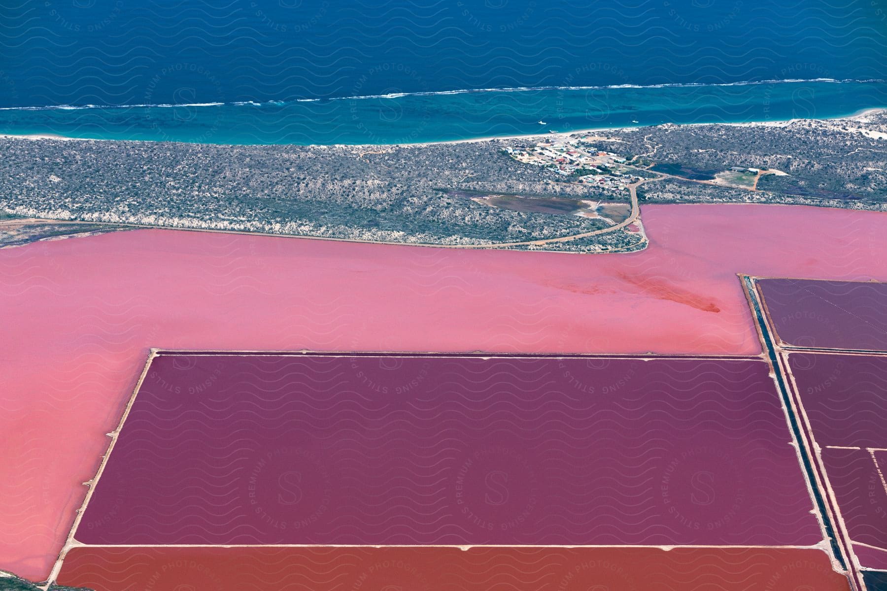 A pink salty lake with artificial ponds used for algae farming in australia