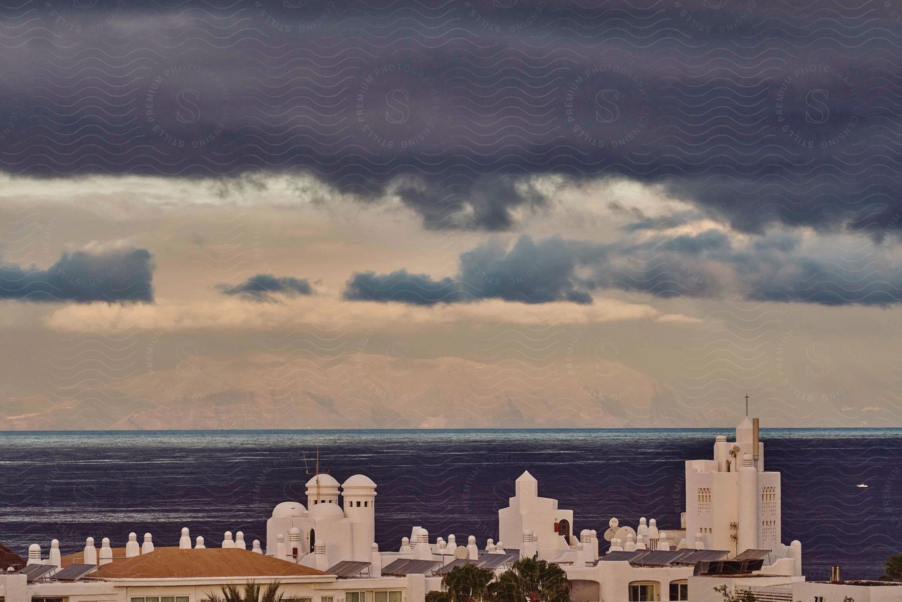 A city near an ocean with a mountain in the distance