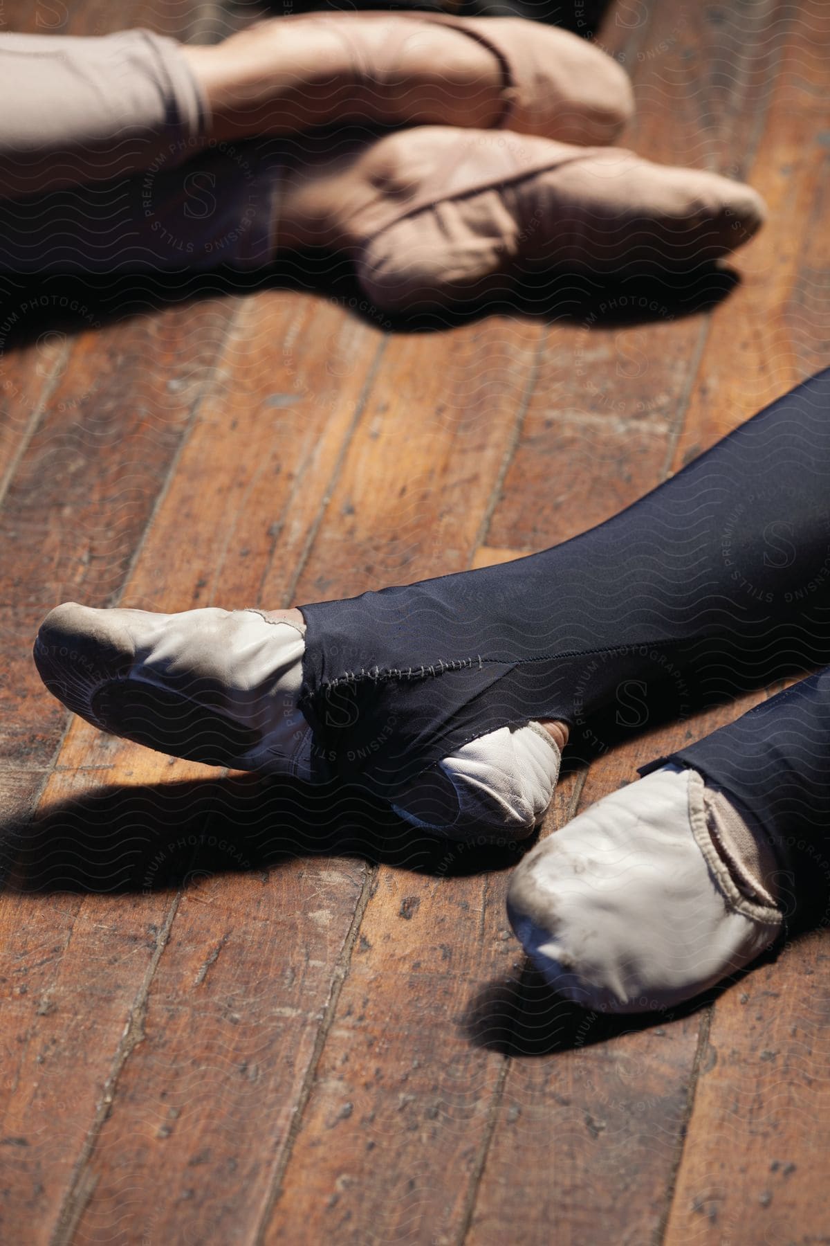 Two ballet dancers feet on a wooden floor indoors