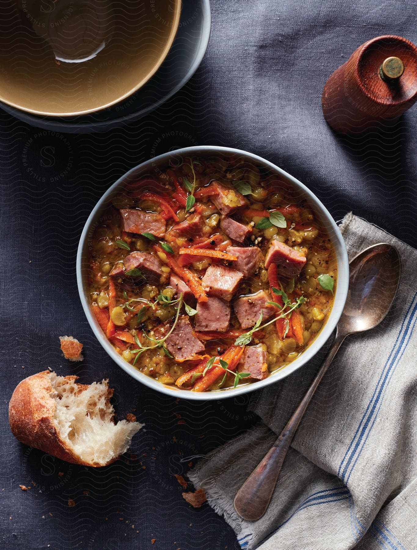 A bowl of food presented on a table with cookware and tableware