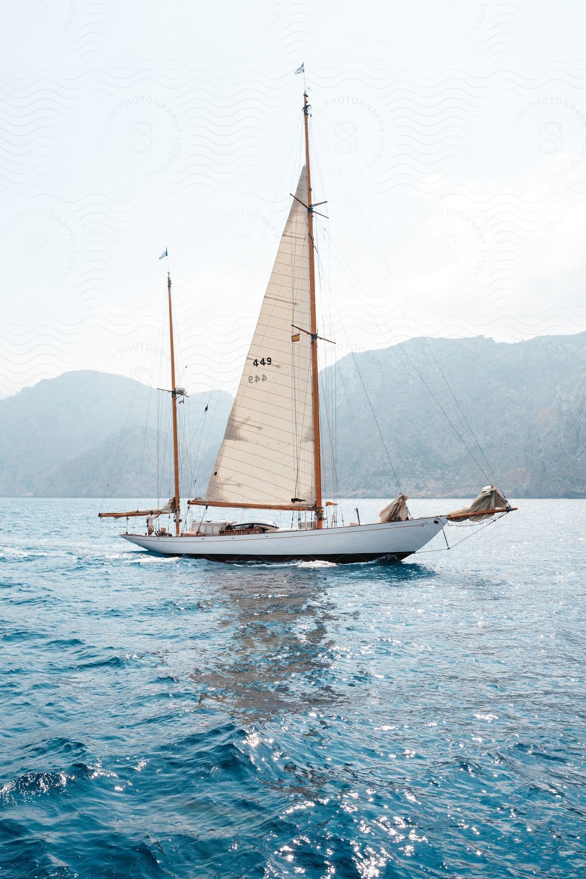 A sailboat near a mountainous coast