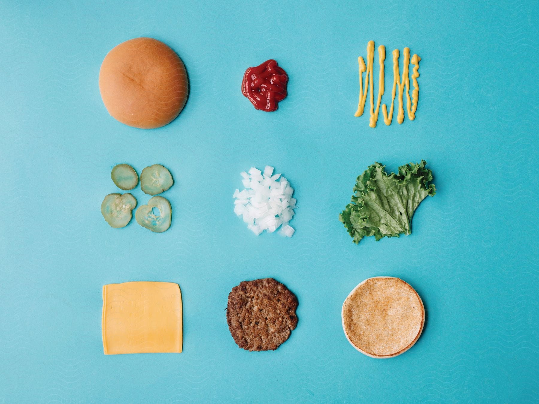 Arrangement of burger ingredients seen from above evenly spaced