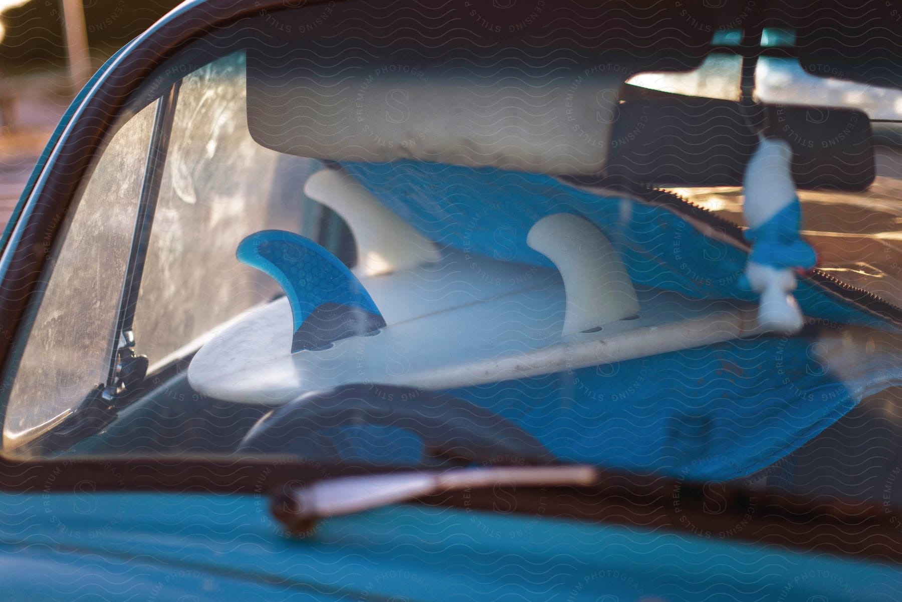 Surfboard inside a car seen through the window