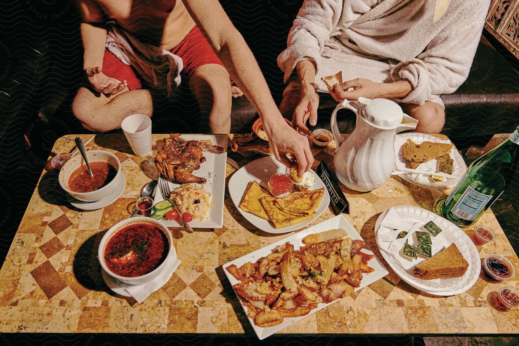 Two adults enjoying a brunch dish with bread and cutlery on a table