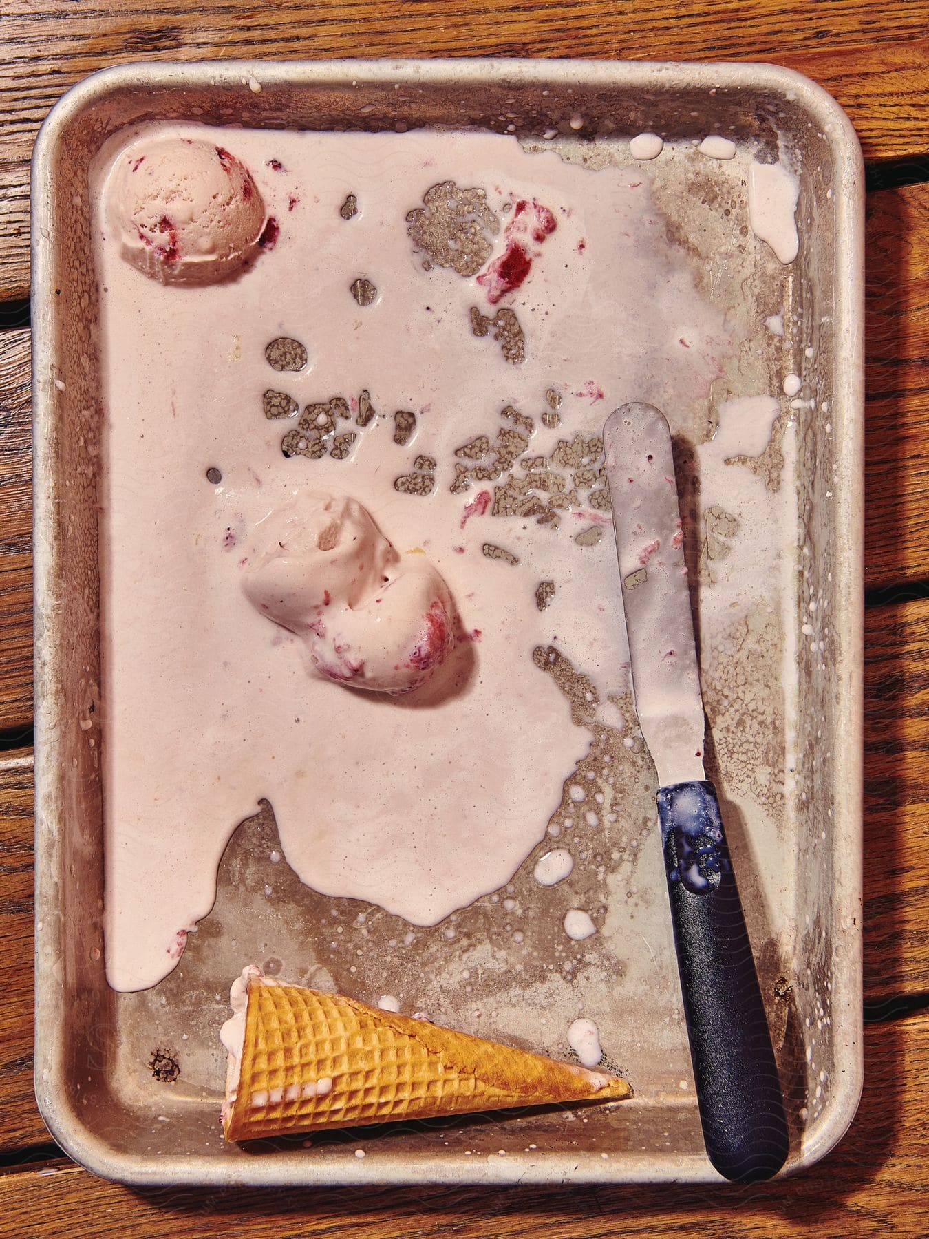 A tray with a knife melted ice cream and an ice cream cone