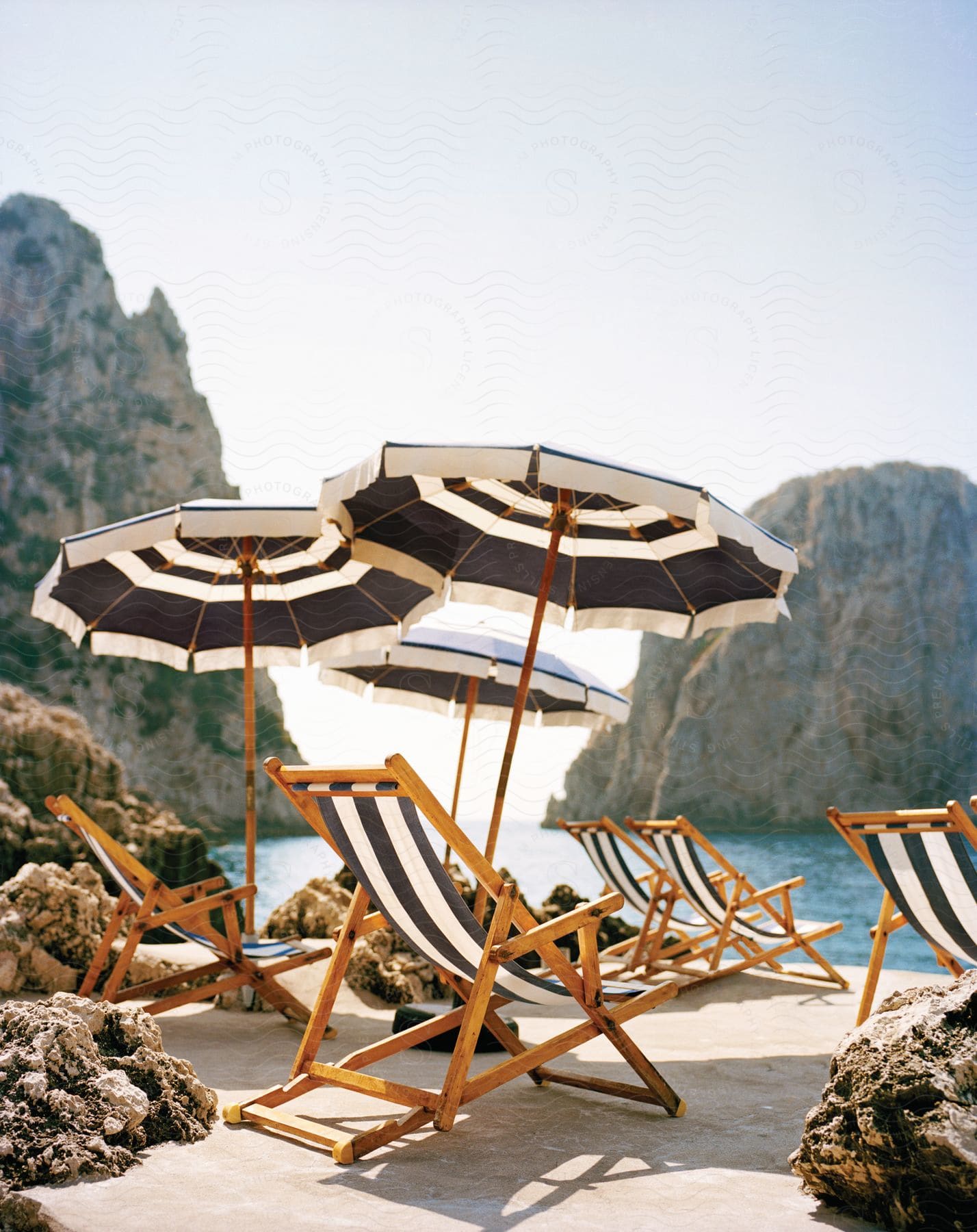 An empty beach with beach chairs and umbrellas on a sunny day