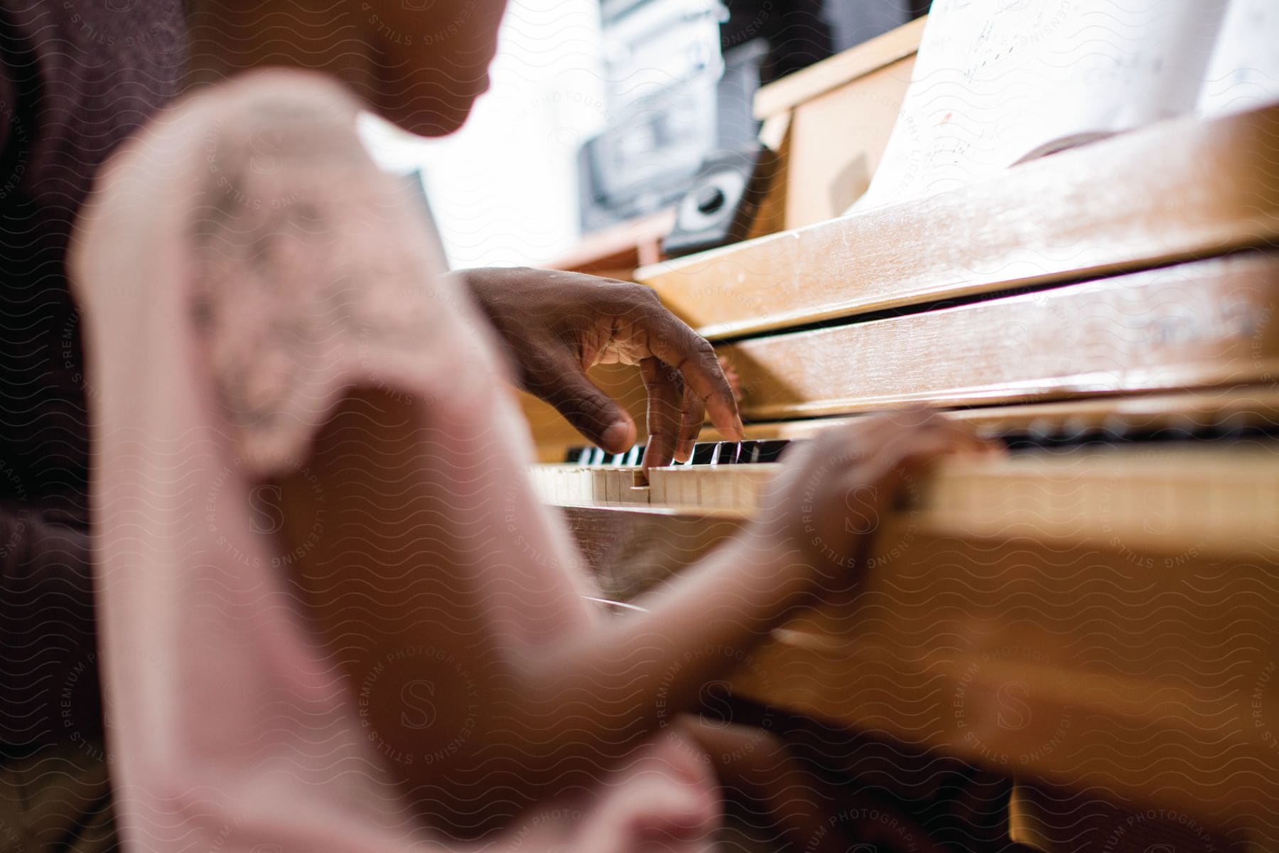 A father teaches his young daughter how to play piano