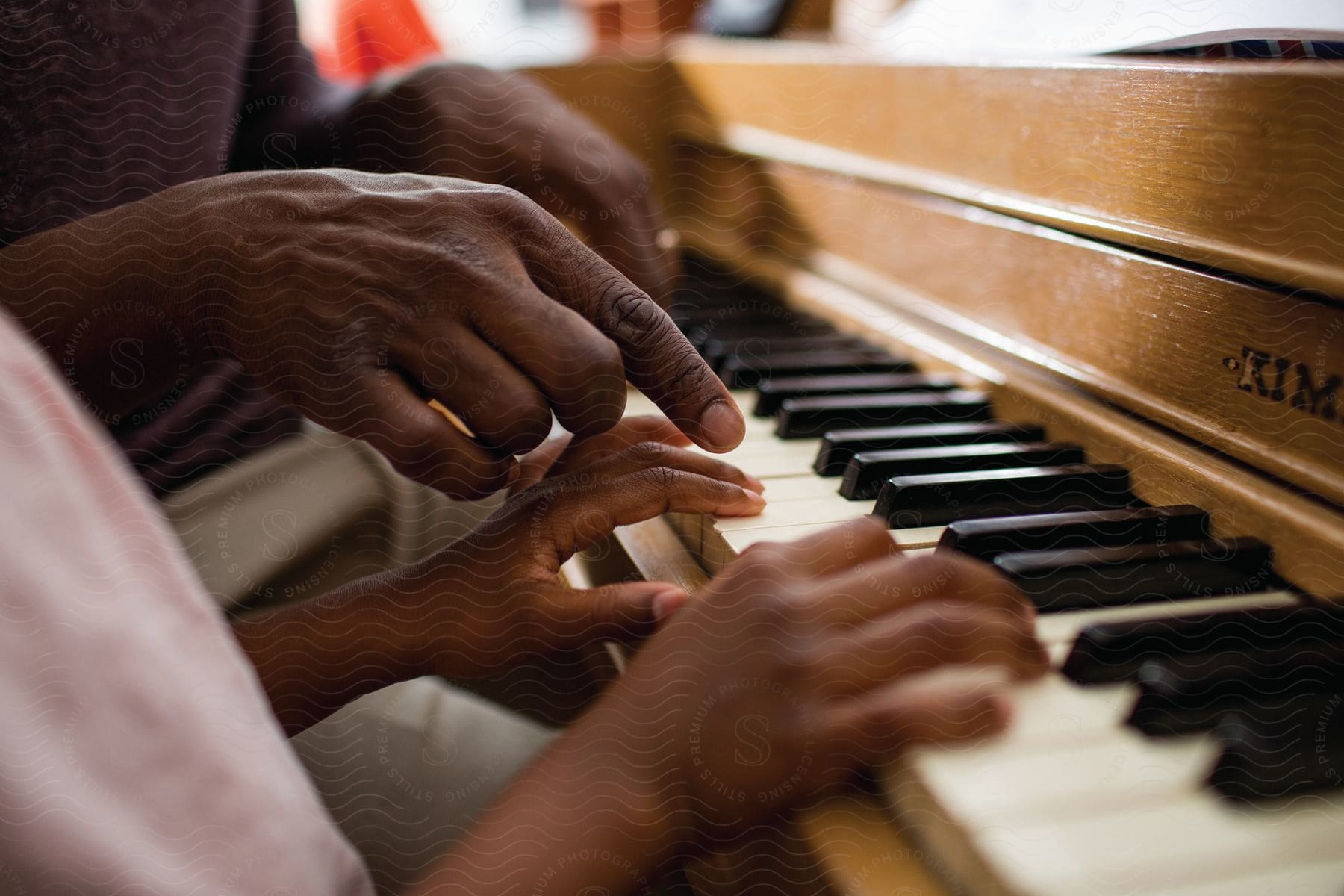 An adult teaches a kid to play the piano