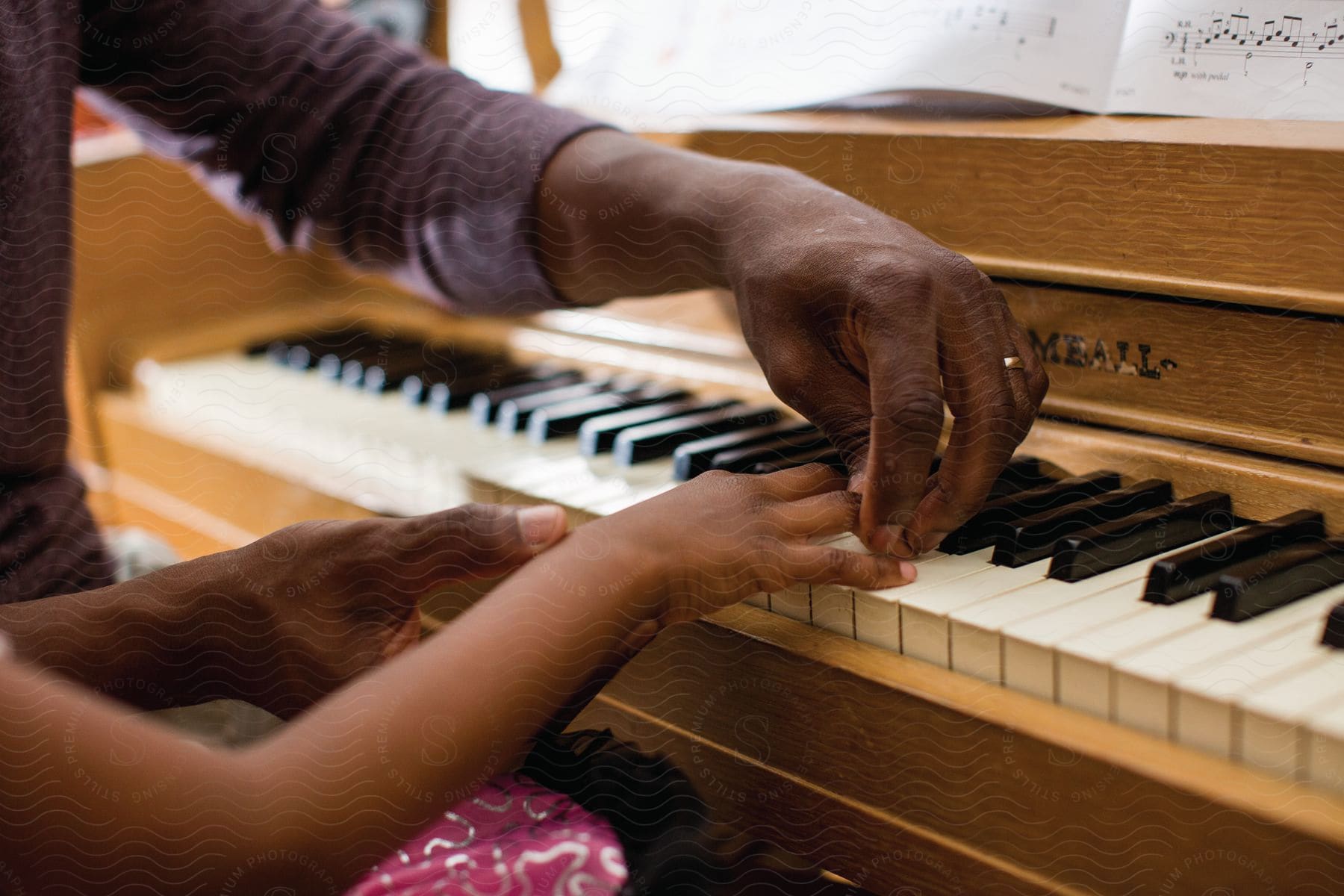 A father and his young daughter engaged in piano lessons