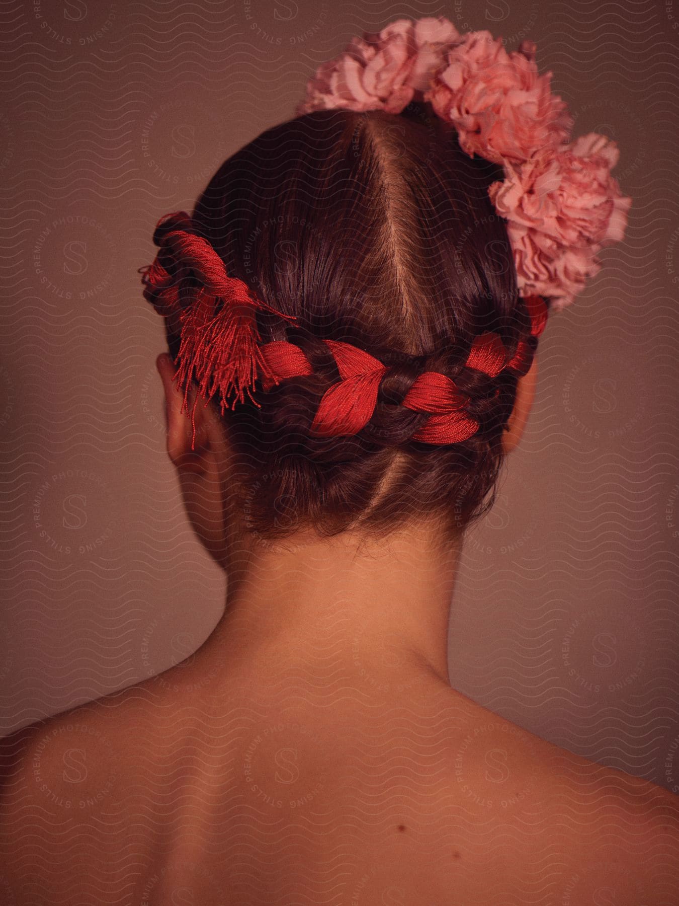 A young woman with braided hair and a floral hair accessory