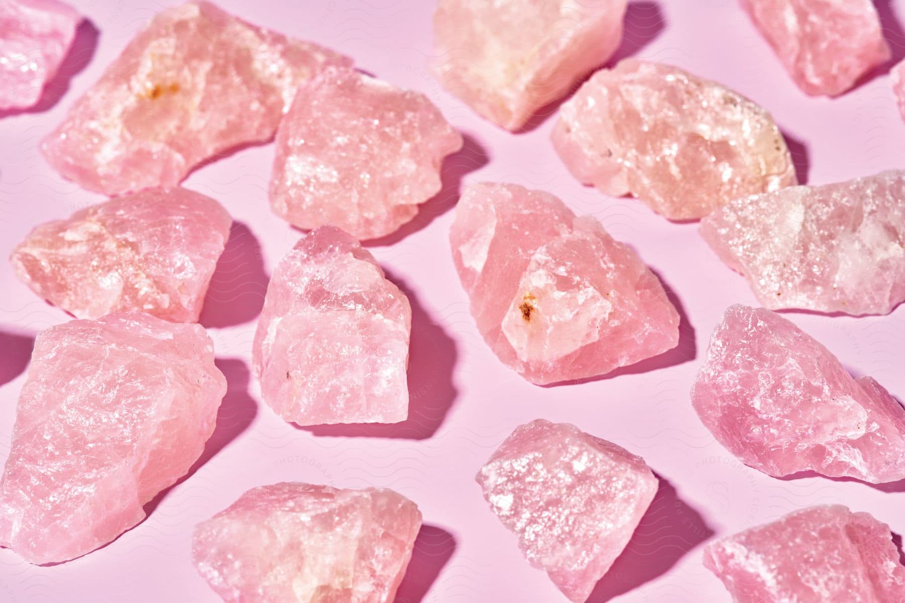 A closeup of pink salt crystals against a pink background