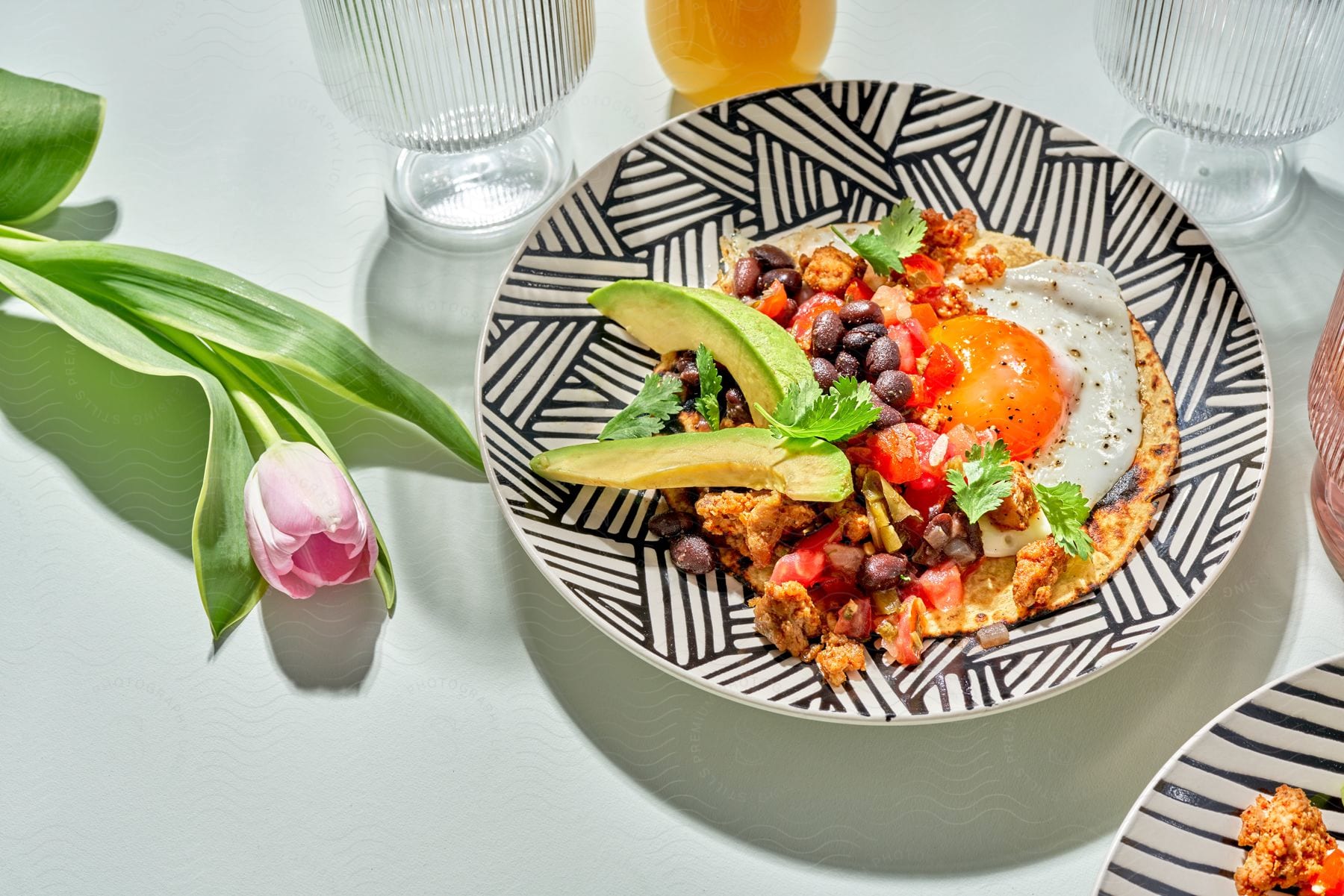 A breakfast dish with eggs is presented on a black and white plate