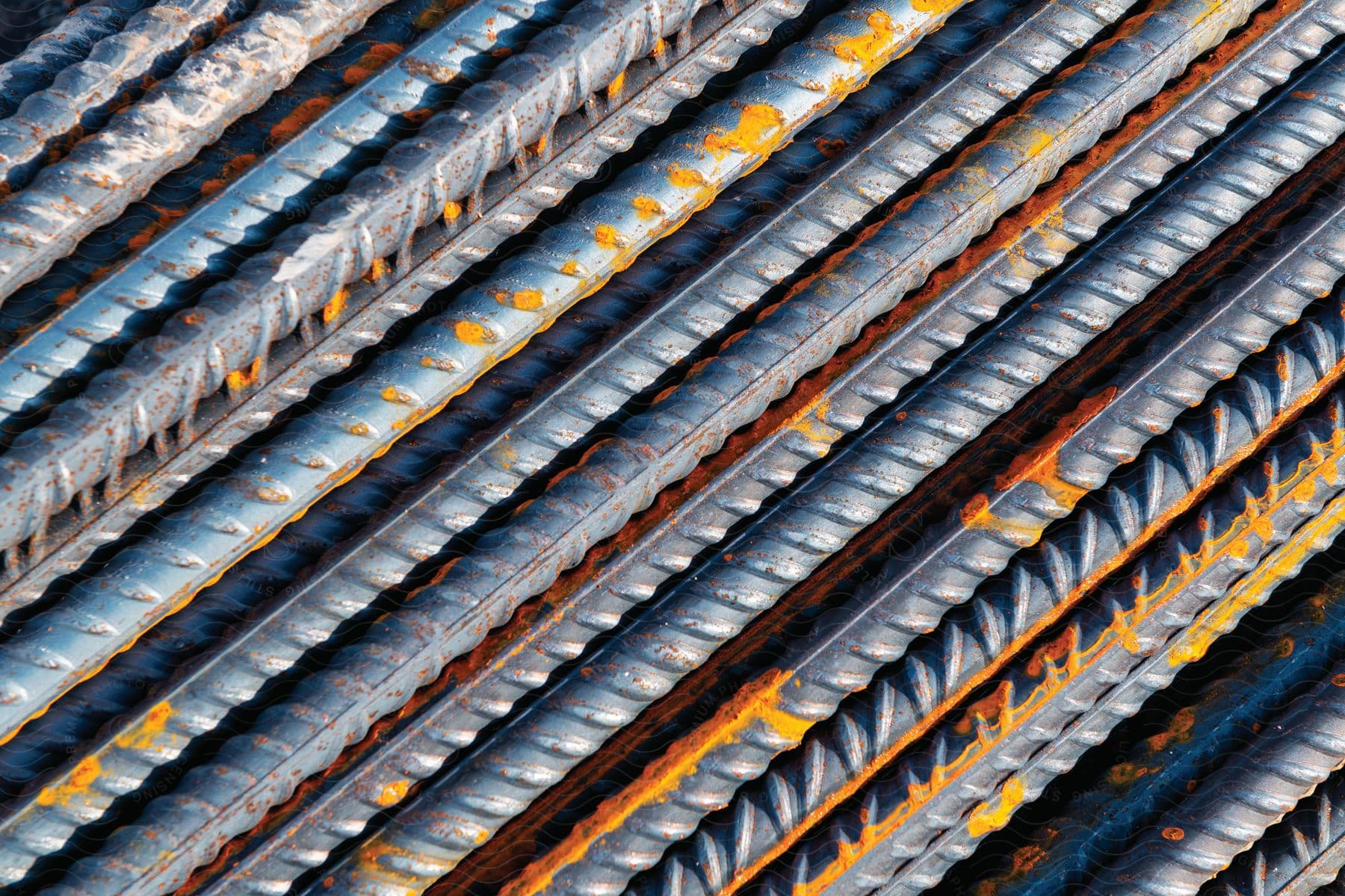 A stack of rebar with yellow paint flaking off