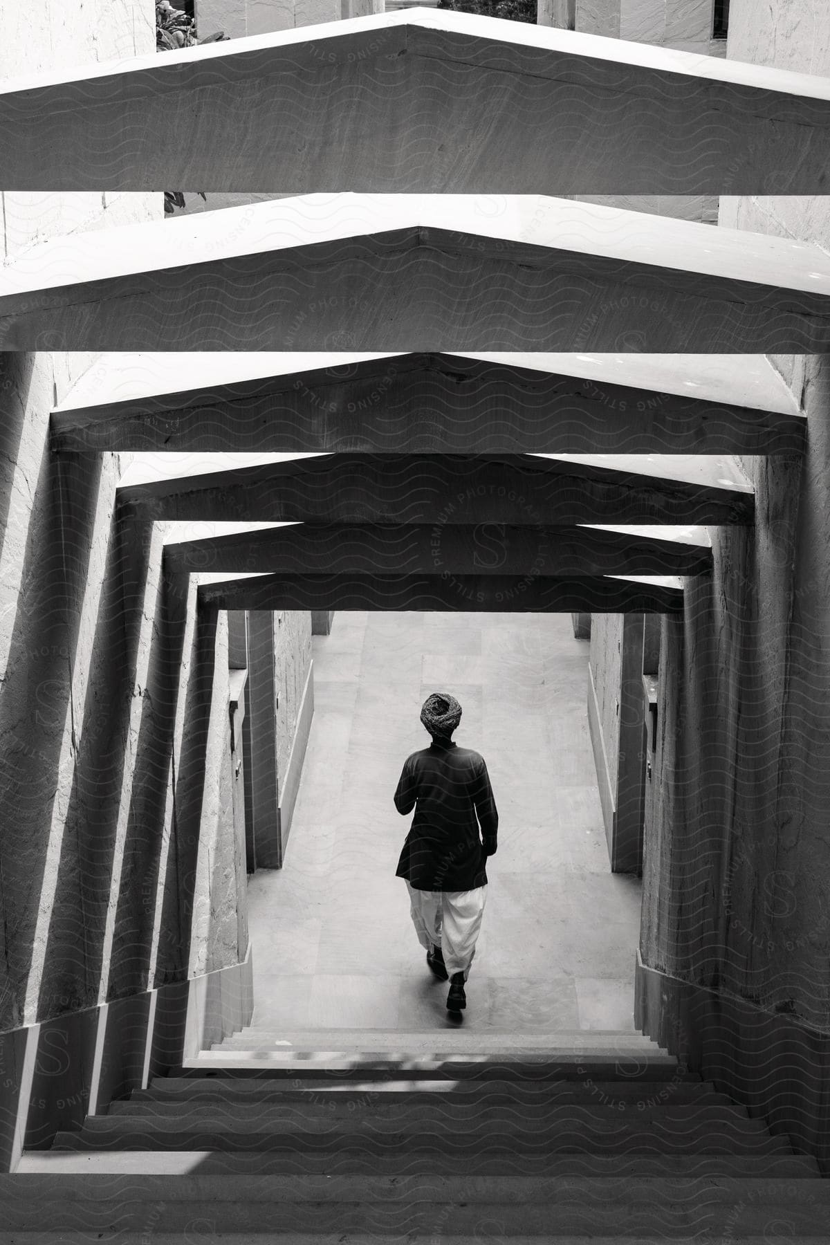 A man walking down a staircase in a black and white image