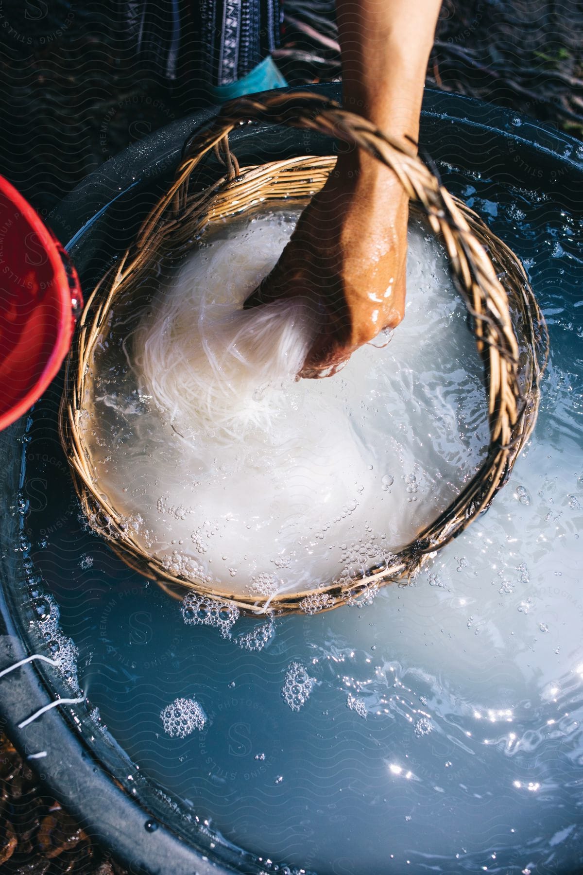 A person rinsing off something in a basket