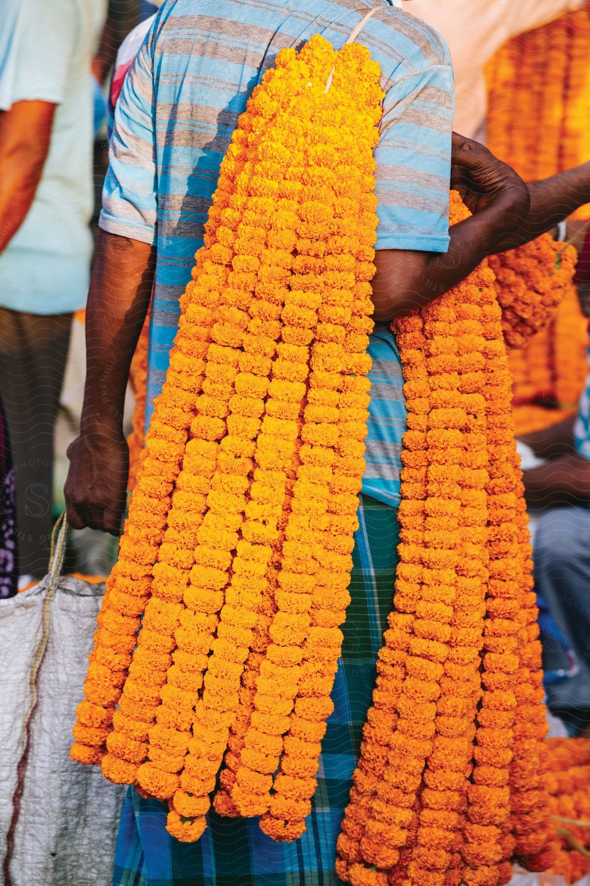 A man carries colorful merchandise through a marketplace