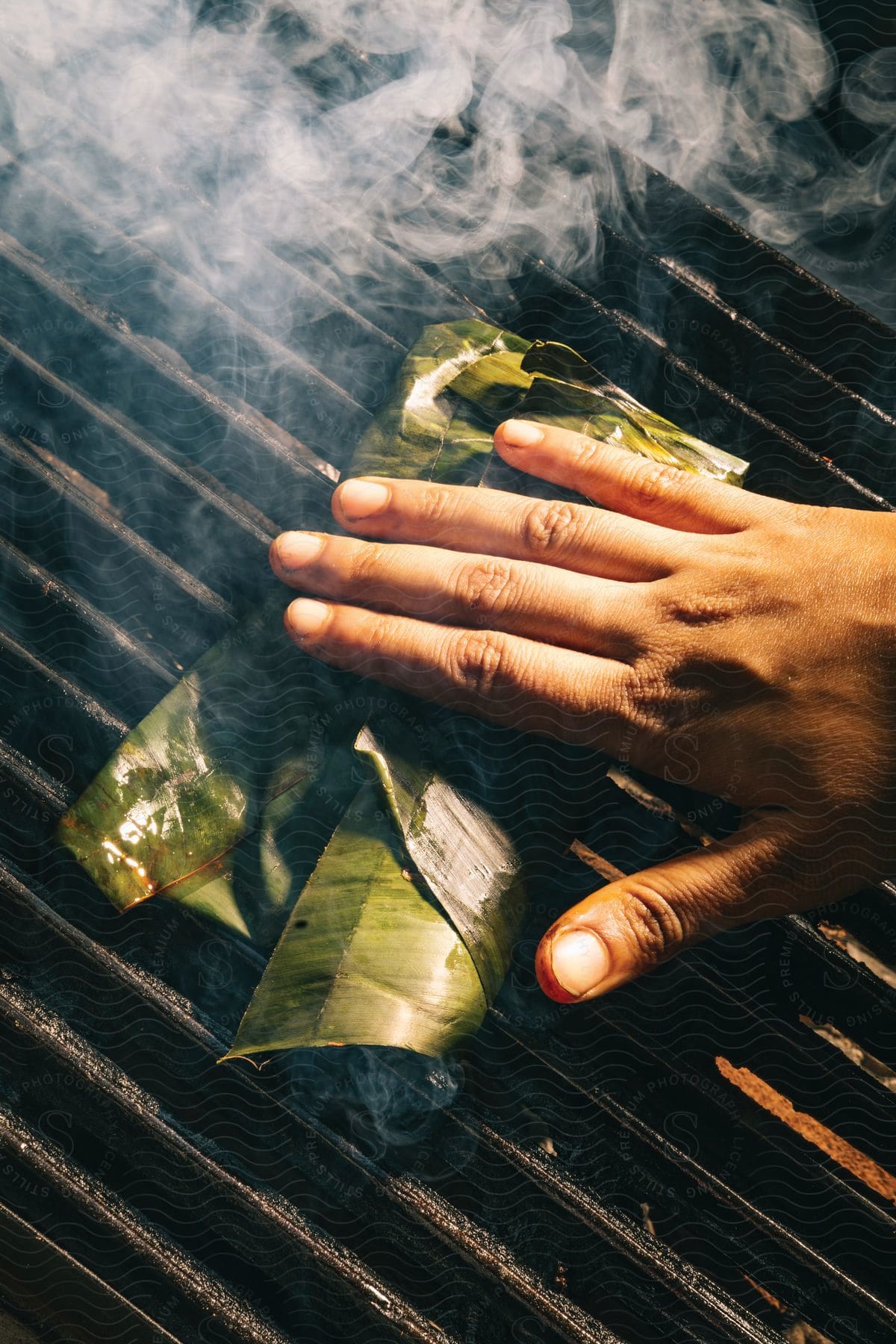 A hand cooking a food folded in a leaf