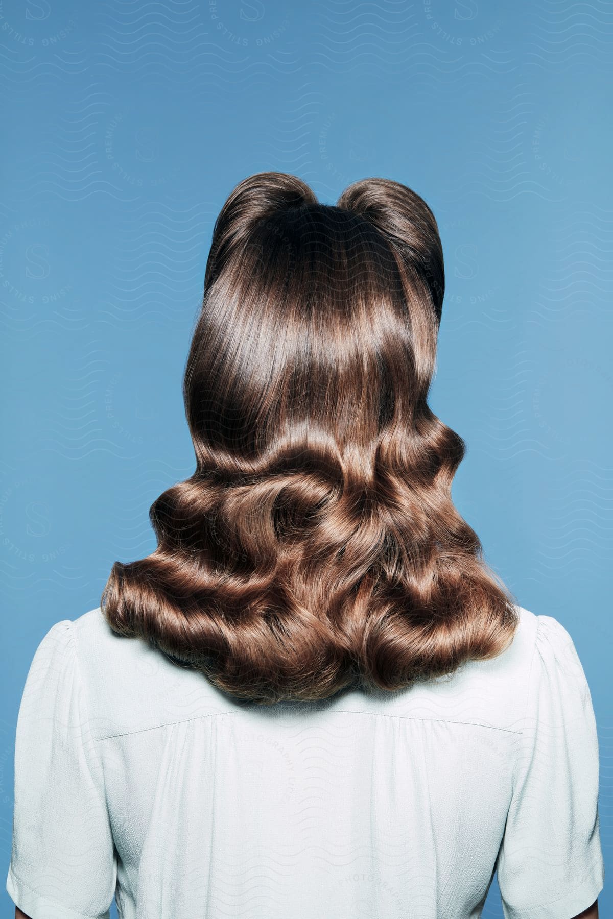 A woman with brown hair has her hair styled in finger waves