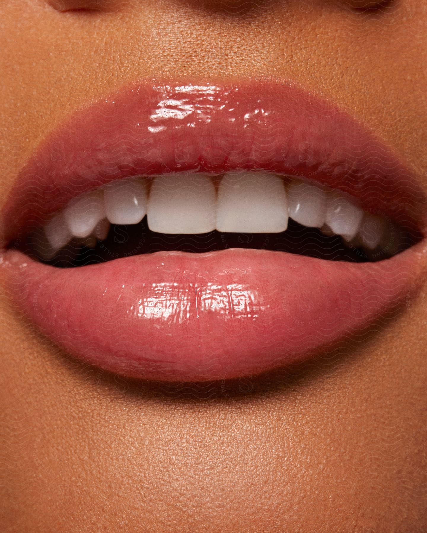 A model wearing pink lip gloss on her mouth