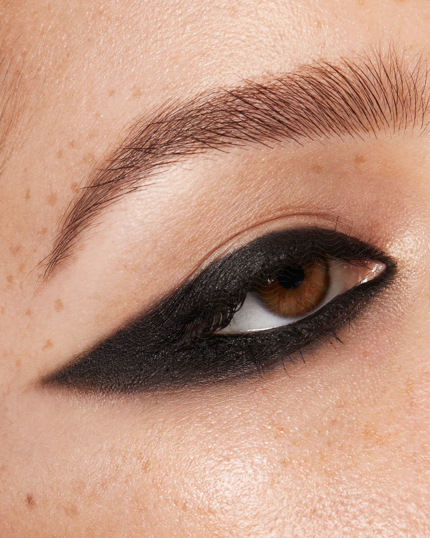 A closeup of a heavily lined eye with black eyeliner