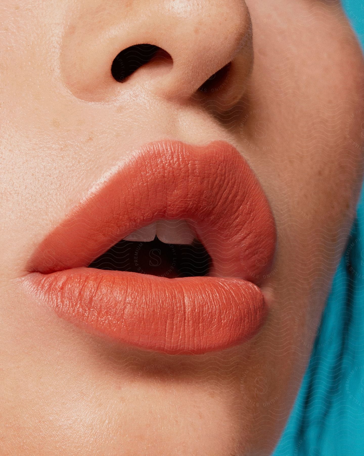 Model wearing light coralcoloured lipstick on her mouth