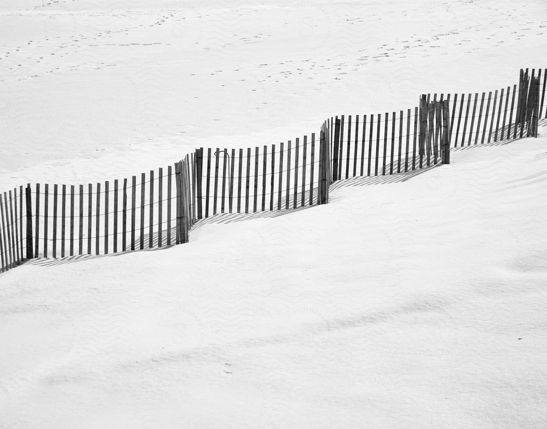 A fence crossing a snowy field