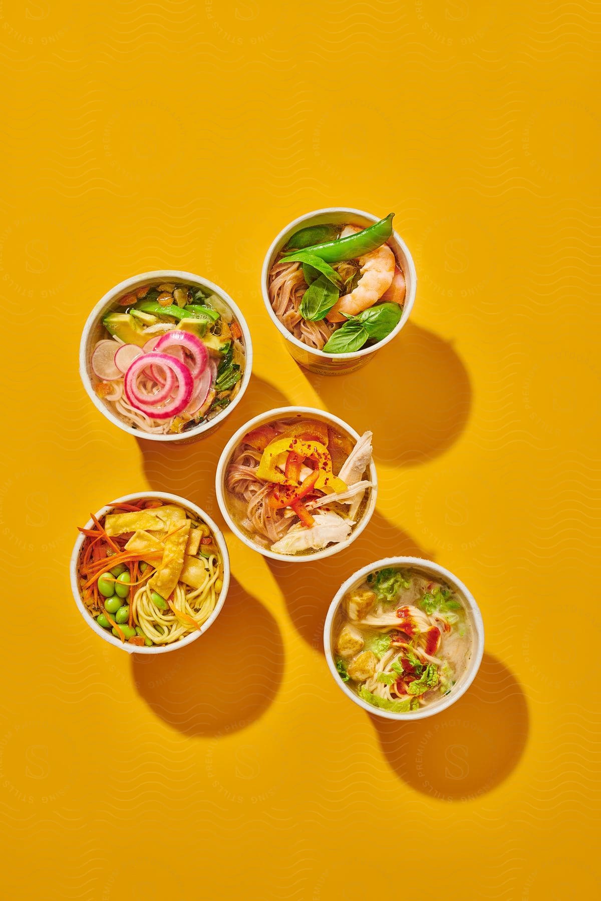 Five cup noodles of various flavors and with different ingredients on top