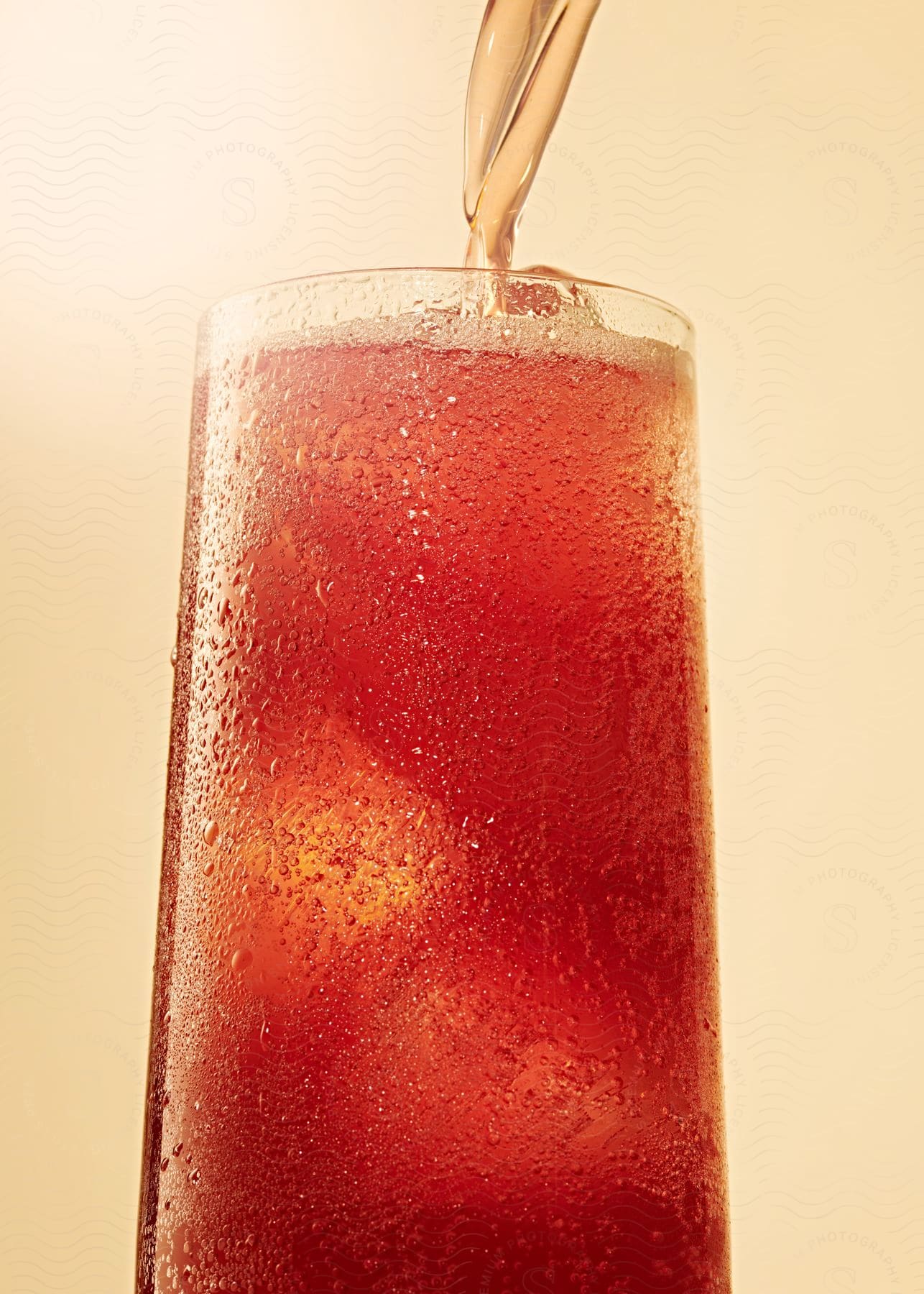 Red Liquid Being Poured Into A Tall Glass