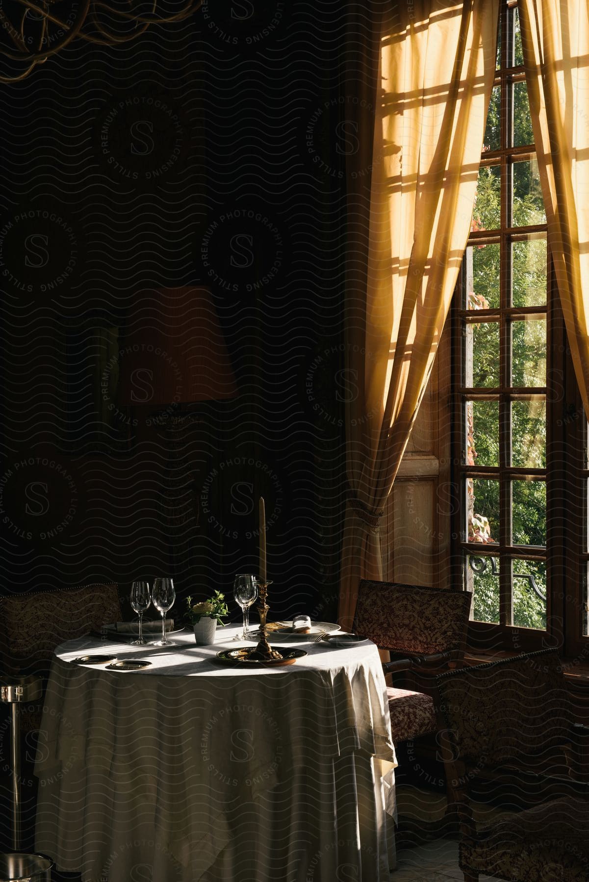 Light shines on a table set with wine glasses