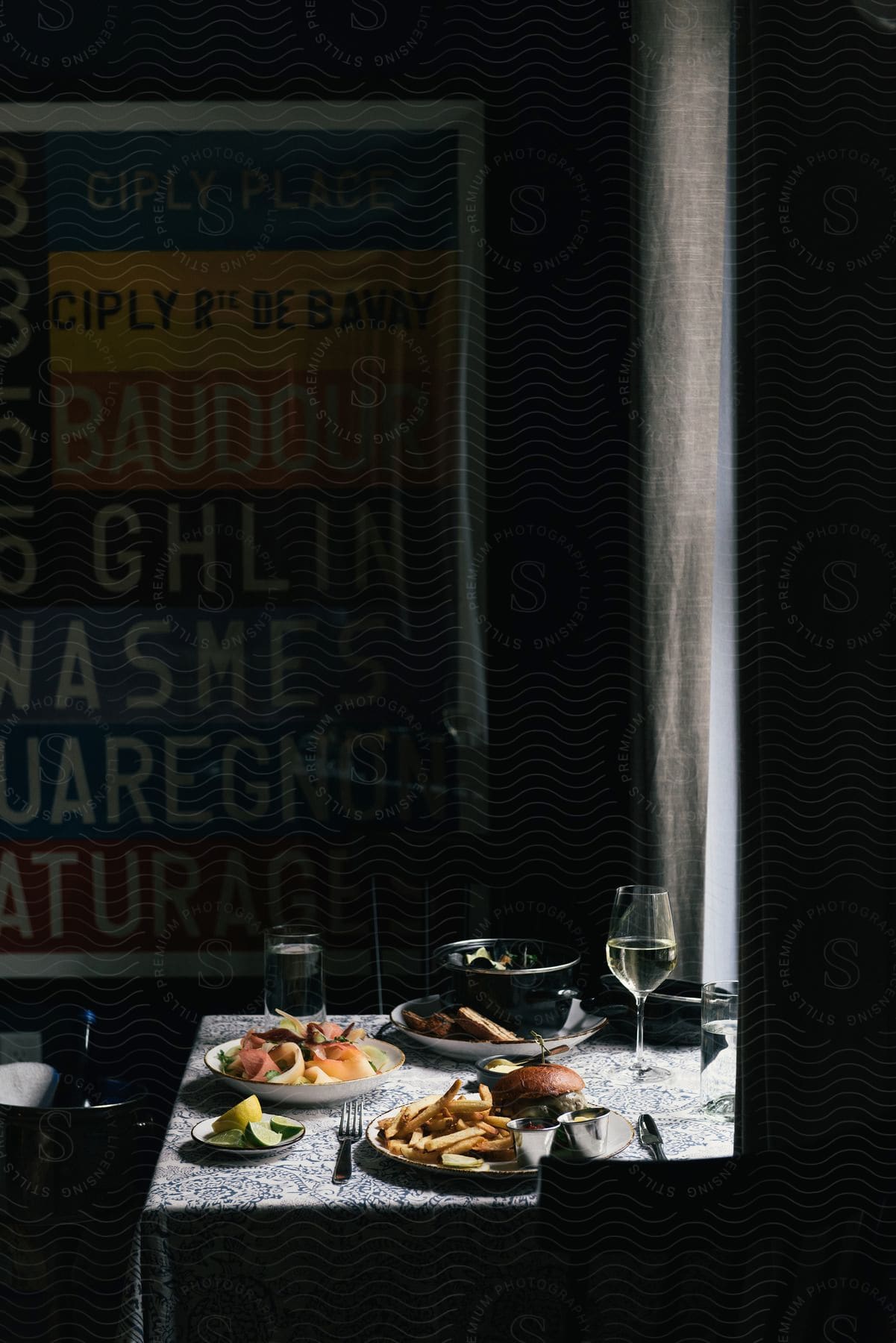 Empty restaurant table for two next to a window with food and drinks served on the table