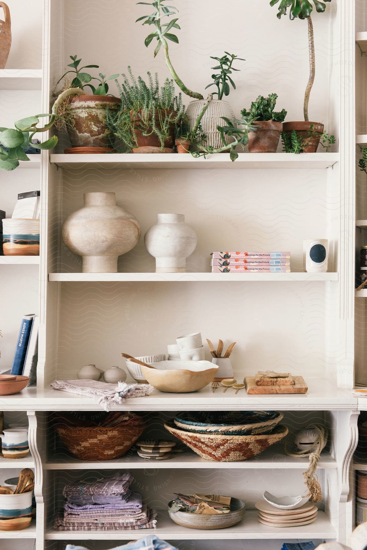 An interior design with wood shelving grey walls and various furniture pieces including a bookcase and a tableware hutch