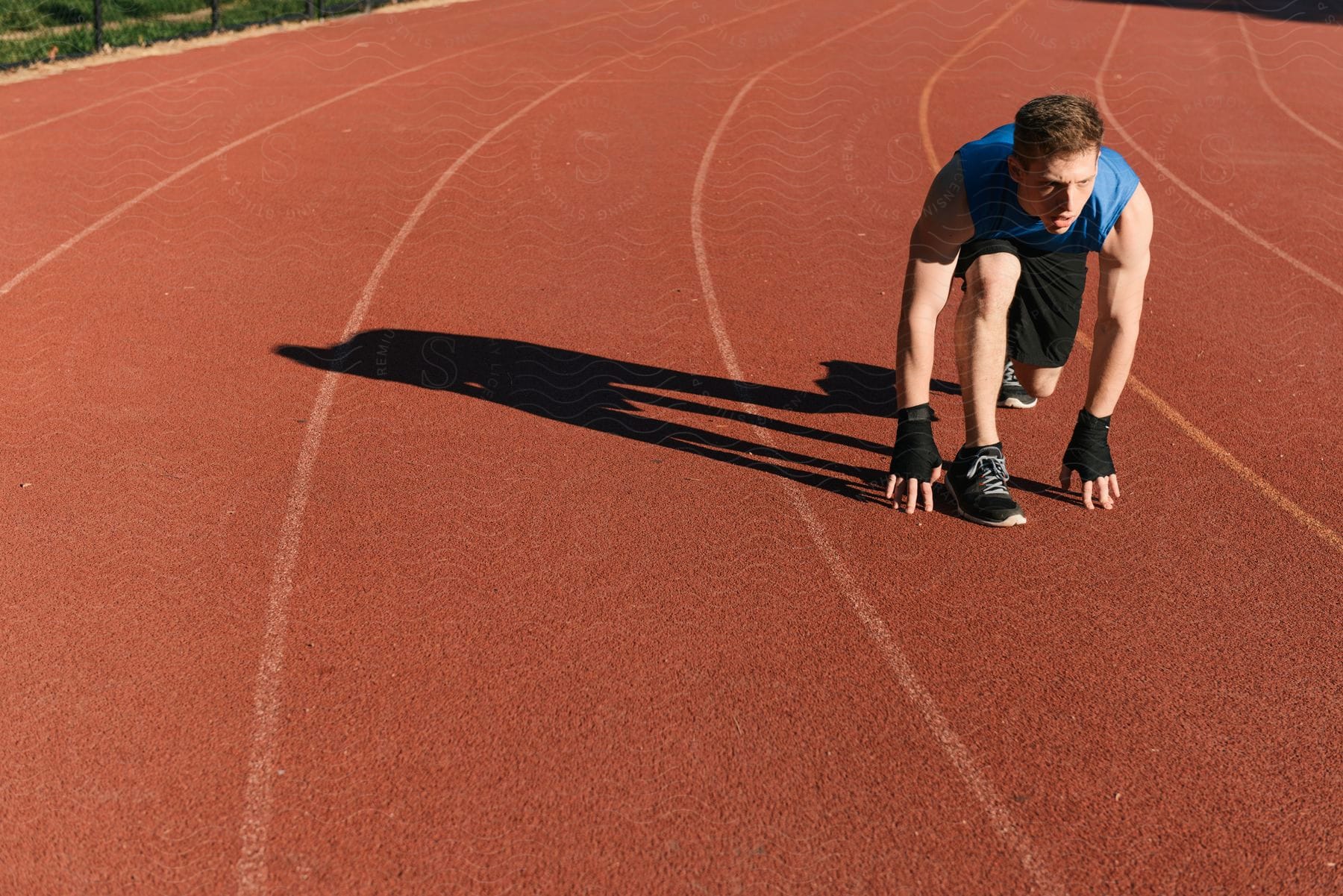 A man is in the starting position on a running track